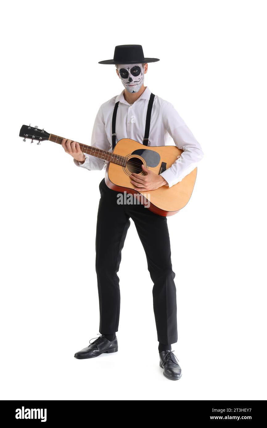 Giovane con teschio dipinto che suona la chitarra su sfondo bianco. Festa del giorno dei morti in Messico (El dia de Muertos) Foto Stock