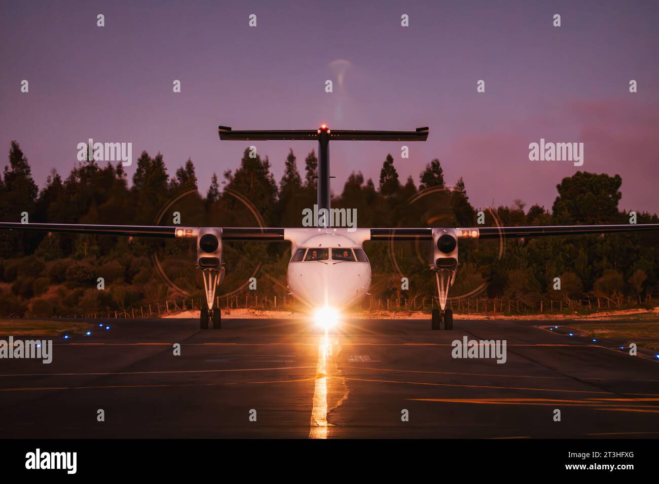 Un aereo turboelica Air New Zealand Q300 "Dash 8" arriva per parcheggiare all'aeroporto di Taupō, in nuova Zelanda, in una notte serena Foto Stock