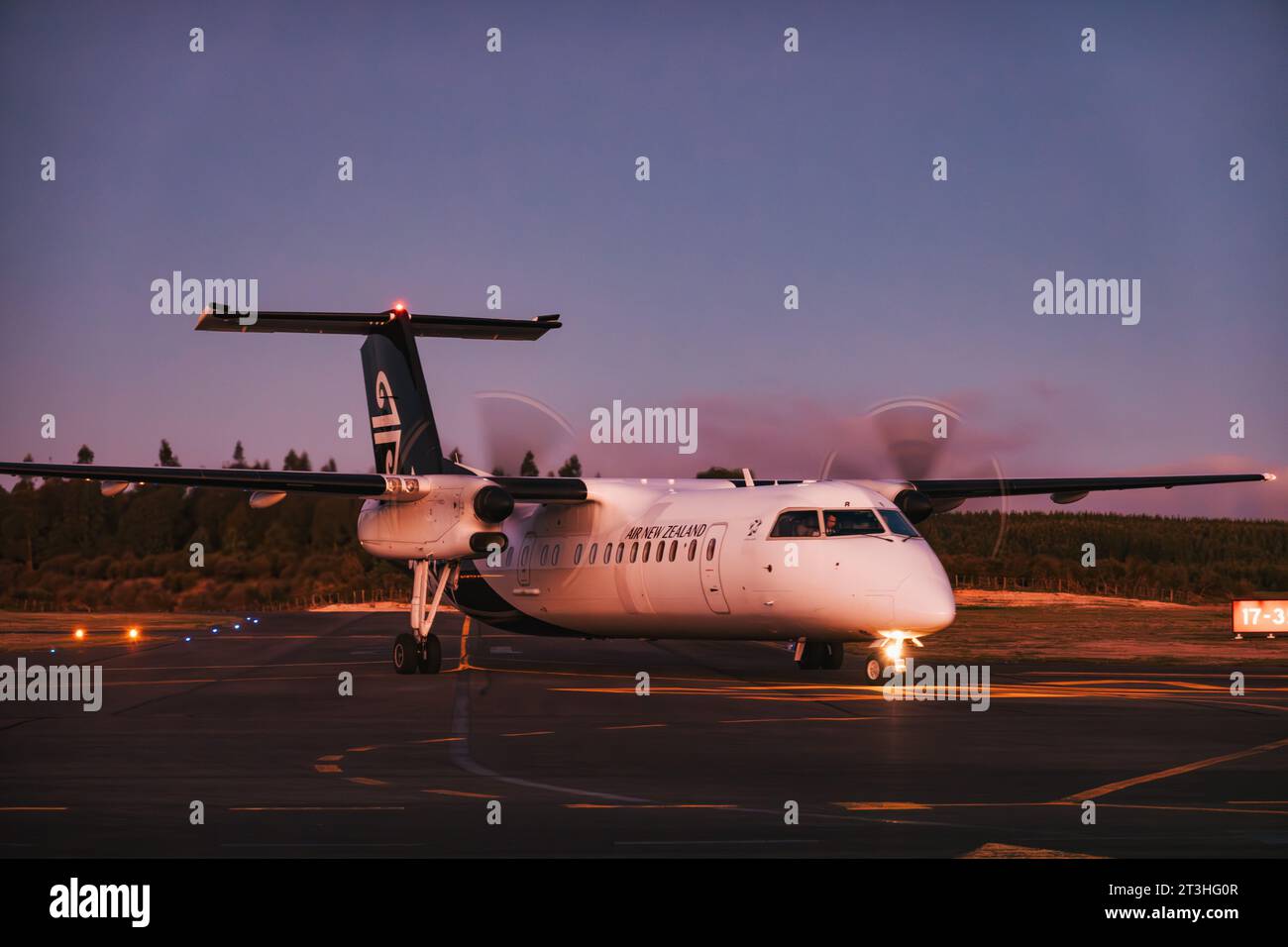Un aereo turboelica Air New Zealand Q300 "Dash 8" arriva per parcheggiare all'aeroporto di Taupō, in nuova Zelanda, in una notte serena Foto Stock