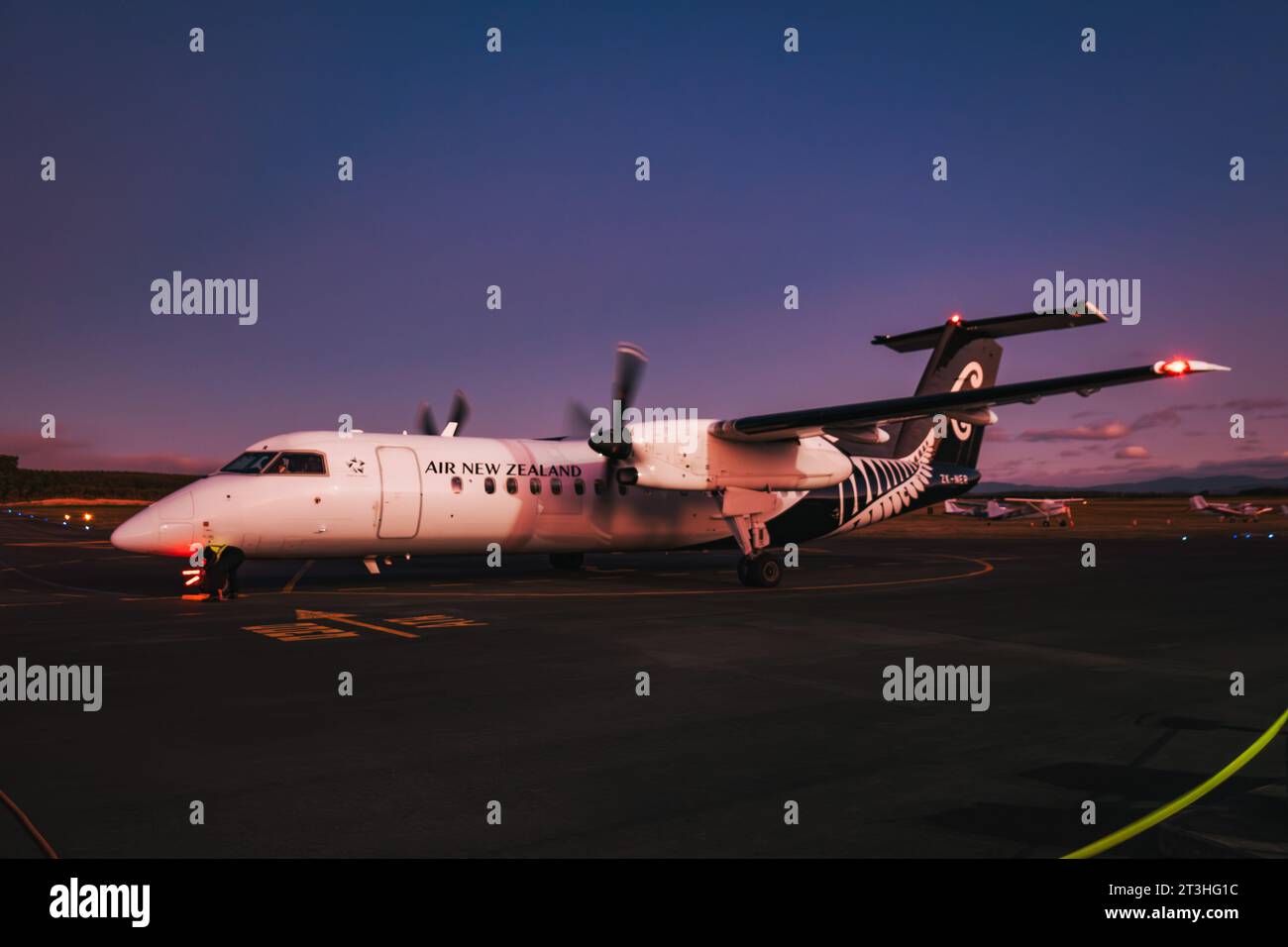 Un aereo turboelica Air New Zealand Q300 "Dash 8" arriva per parcheggiare all'aeroporto di Taupō, in nuova Zelanda, in una notte serena Foto Stock