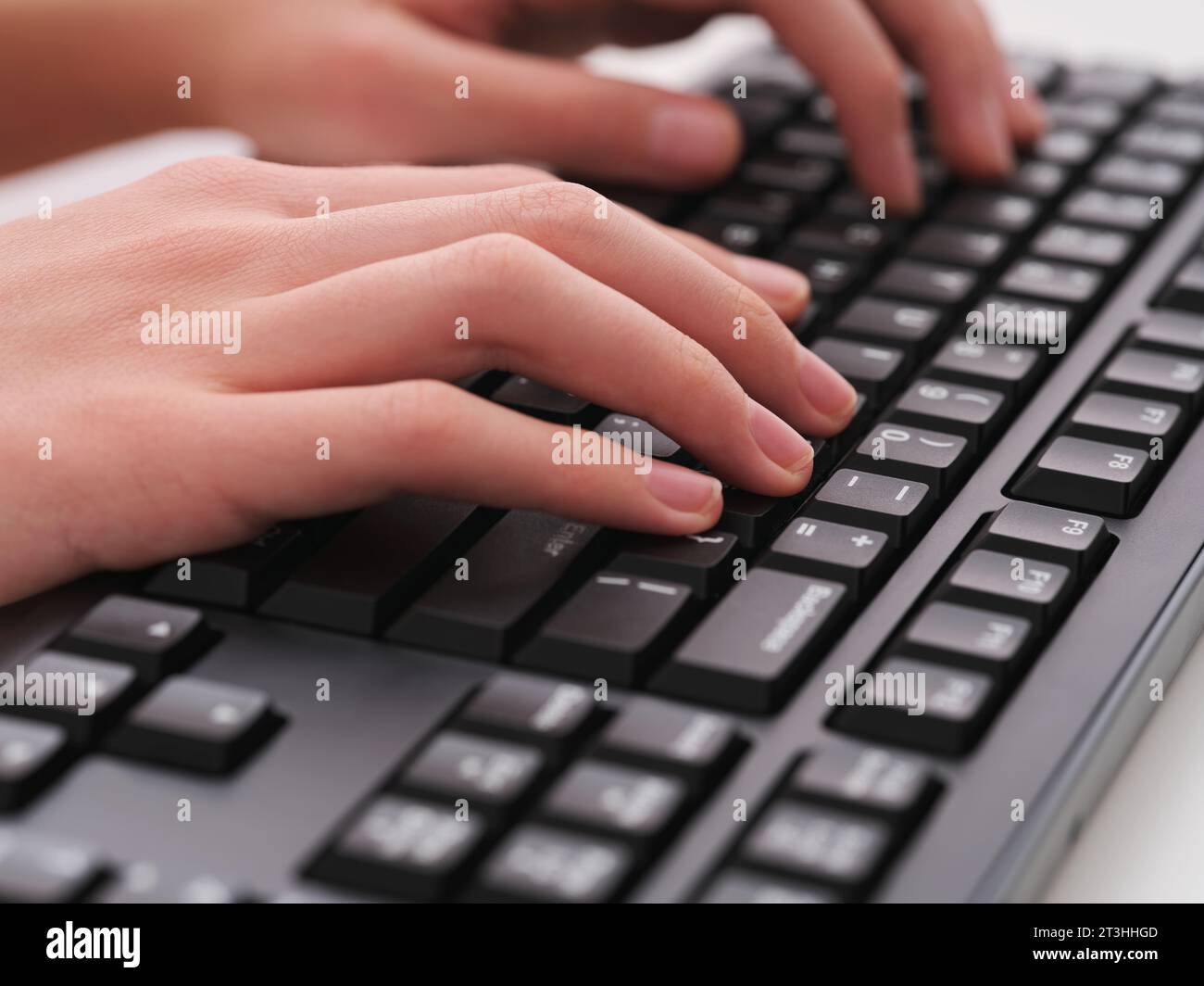 Un giovane che digita su una tastiera nera del computer. Primo piano. Foto Stock