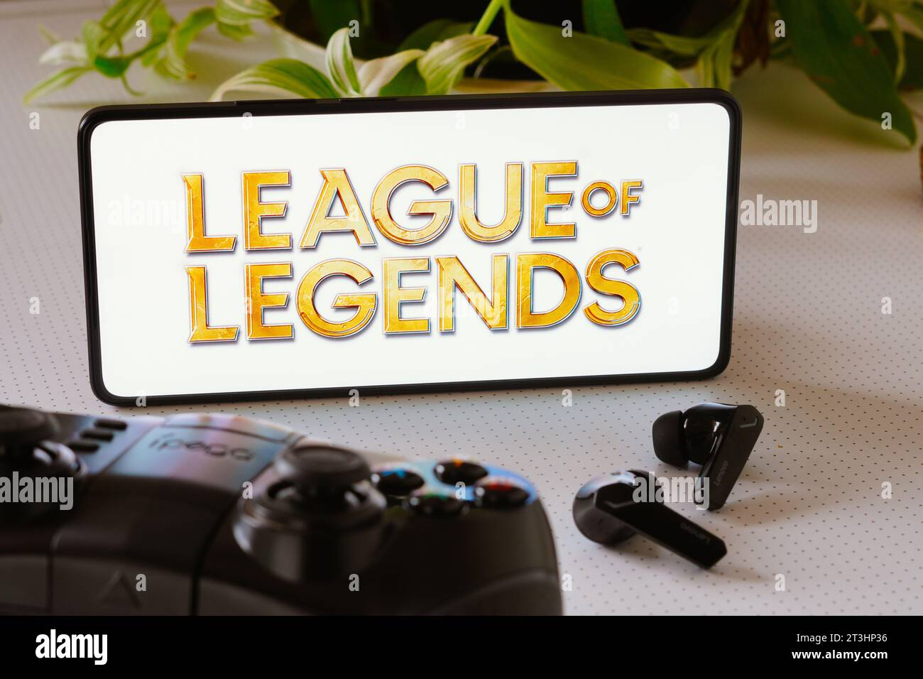 Brasile. 25 ottobre 2023. In questa foto, il logo del gioco League of Legends viene visualizzato sullo schermo di uno smartphone, accanto a un gamepad e alle cuffie. Credito: SOPA Images Limited/Alamy Live News Foto Stock