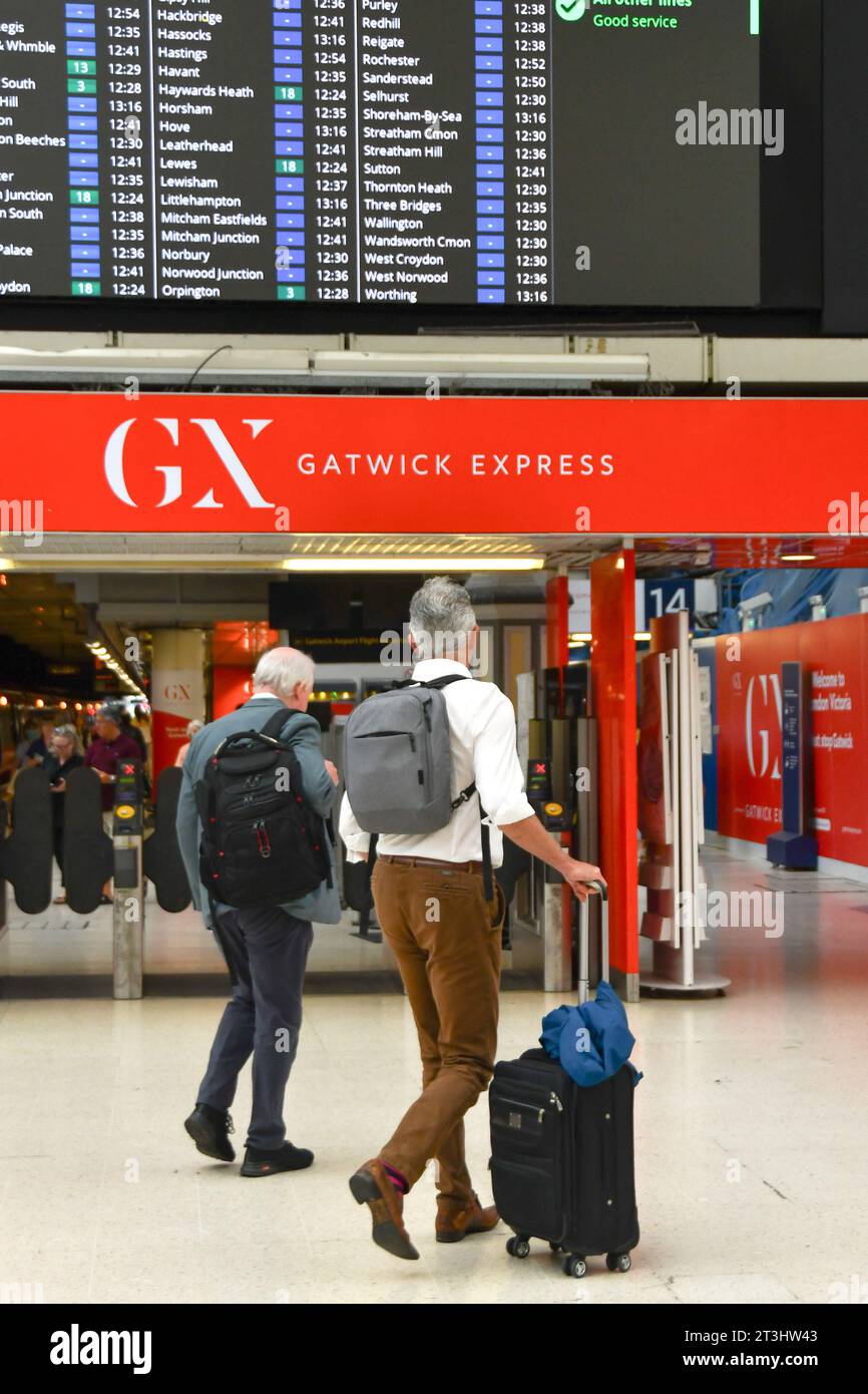 Londra, Inghilterra, Regno Unito - 28 giugno 2023: Due persone camminano verso la piattaforma per il collegamento ferroviario Gatwick Express alla stazione ferroviaria di Victoria Foto Stock