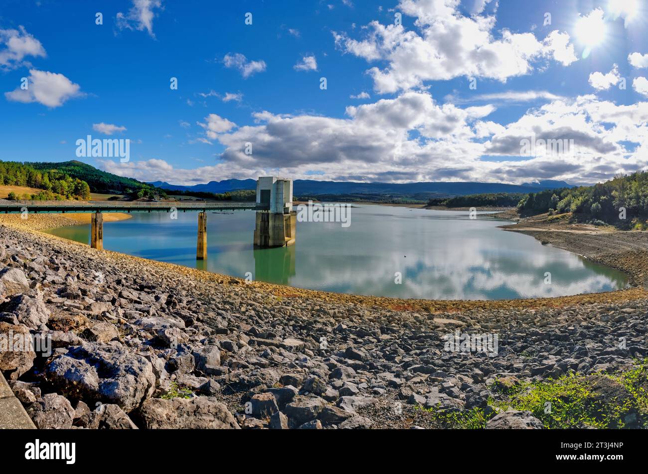 Lago Montbel Areige Francia 24.10.23 vicino a serbatoio vuoto. ripidi banchi di roccia e fango. Torre di controllo valvola dell'acqua in calcestruzzo e strada rialzata. Colline e fango Foto Stock
