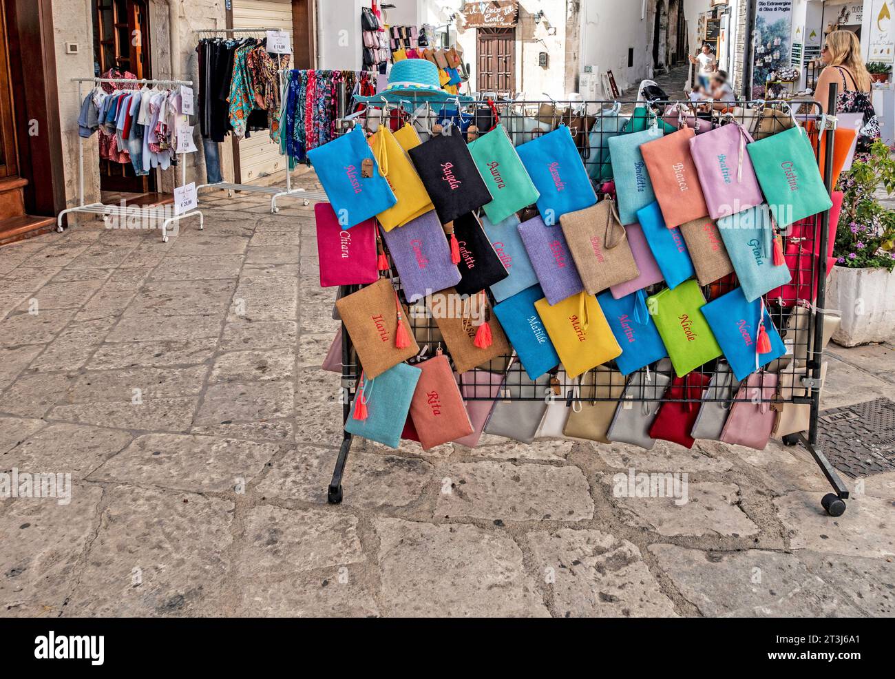 Un negozio di abbigliamento femminile a Ostuni, Italia, con una colorata esposizione di accessori di abbigliamento. Foto Stock