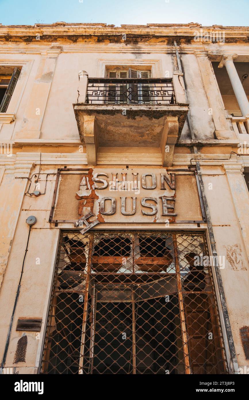 Un vecchio cartello sopra una porta di un negozio di moda a Varosha, un sobborgo della città di Famagosta, Cipro, abbandonato dal 1974 Foto Stock