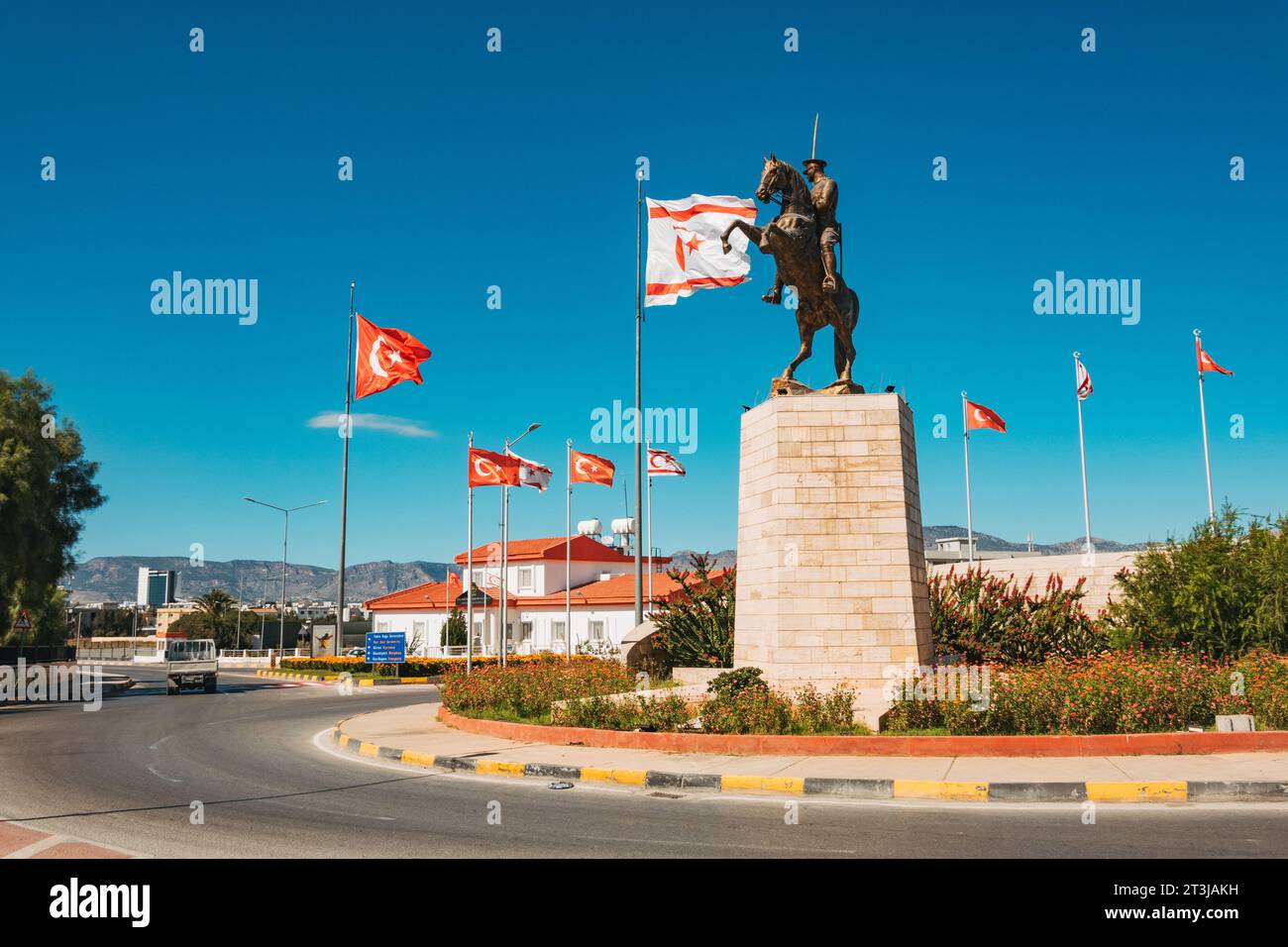 Le bandiere di Türkiye e Cipro settentrionale volano accanto a una statua di Atatürk a cavallo in una rotatoria a nord di Nicosia Foto Stock