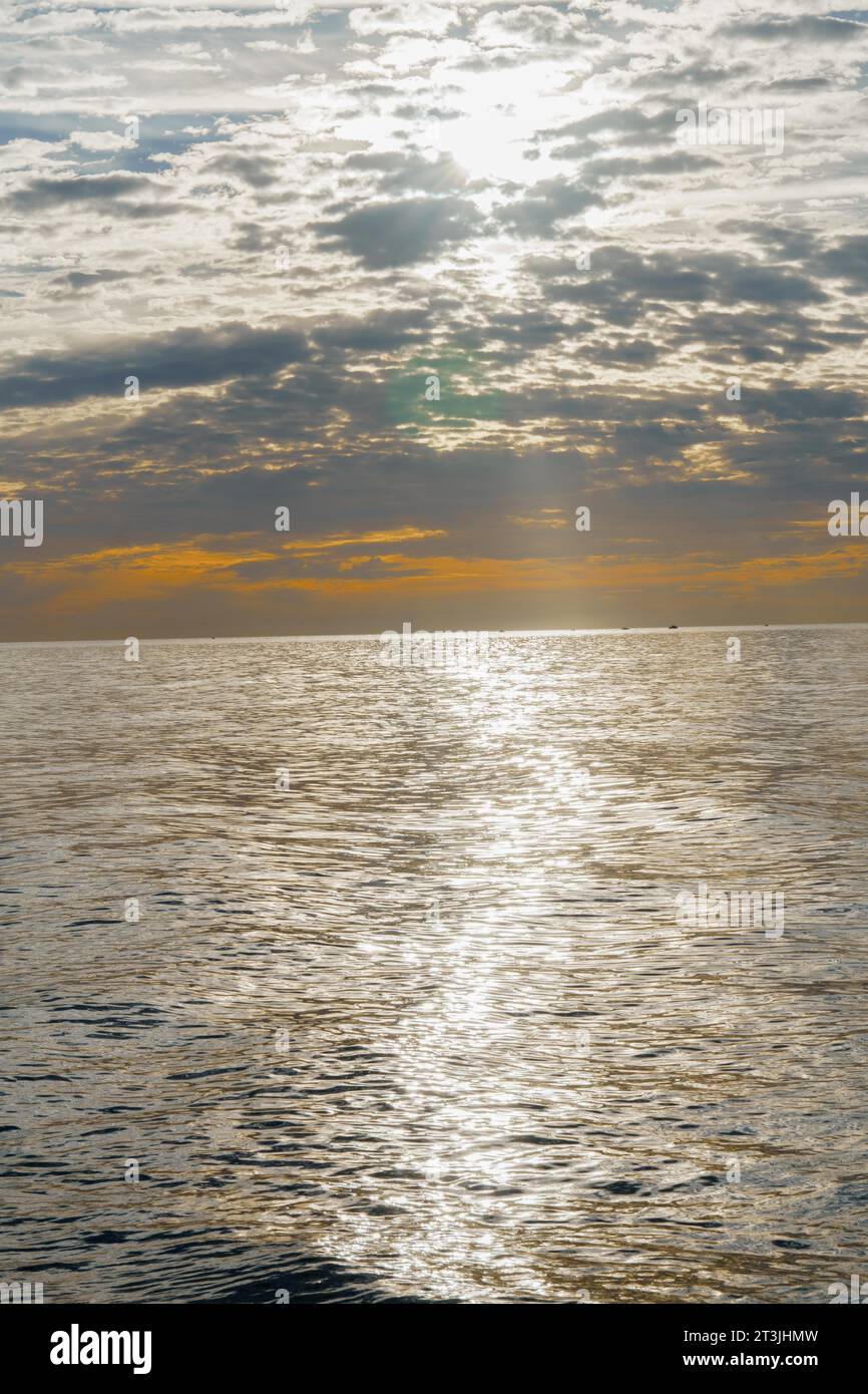 San pedro alcantara, malaga, spagna, mare calmo in un paesaggio marino all'alba con un cielo coperto colorato Foto Stock
