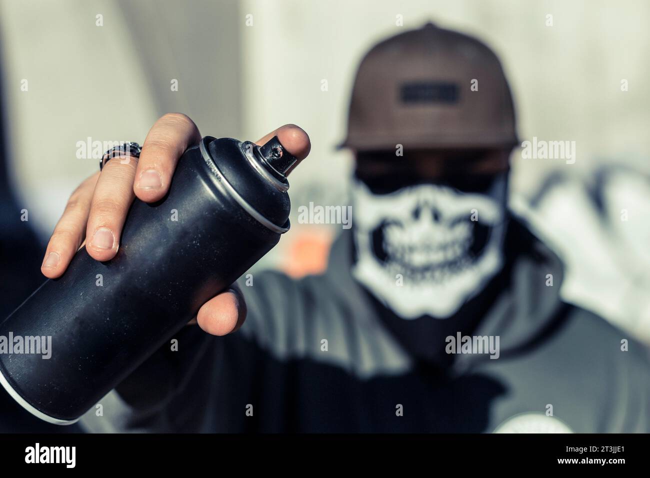 Avvicinare la mano di un uomo che tiene in mano la bomboletta di aerosol nero Foto Stock