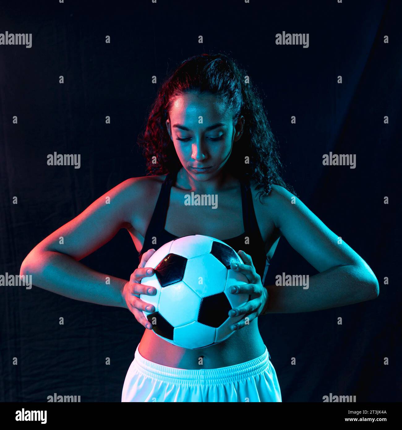 Vista frontale in forma femminile con pallone da calcio Foto Stock