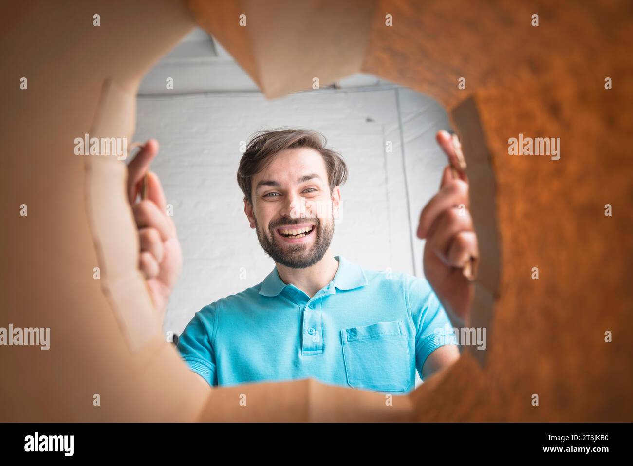 Un uomo felice che guarda dentro un sacchetto di carta Foto Stock
