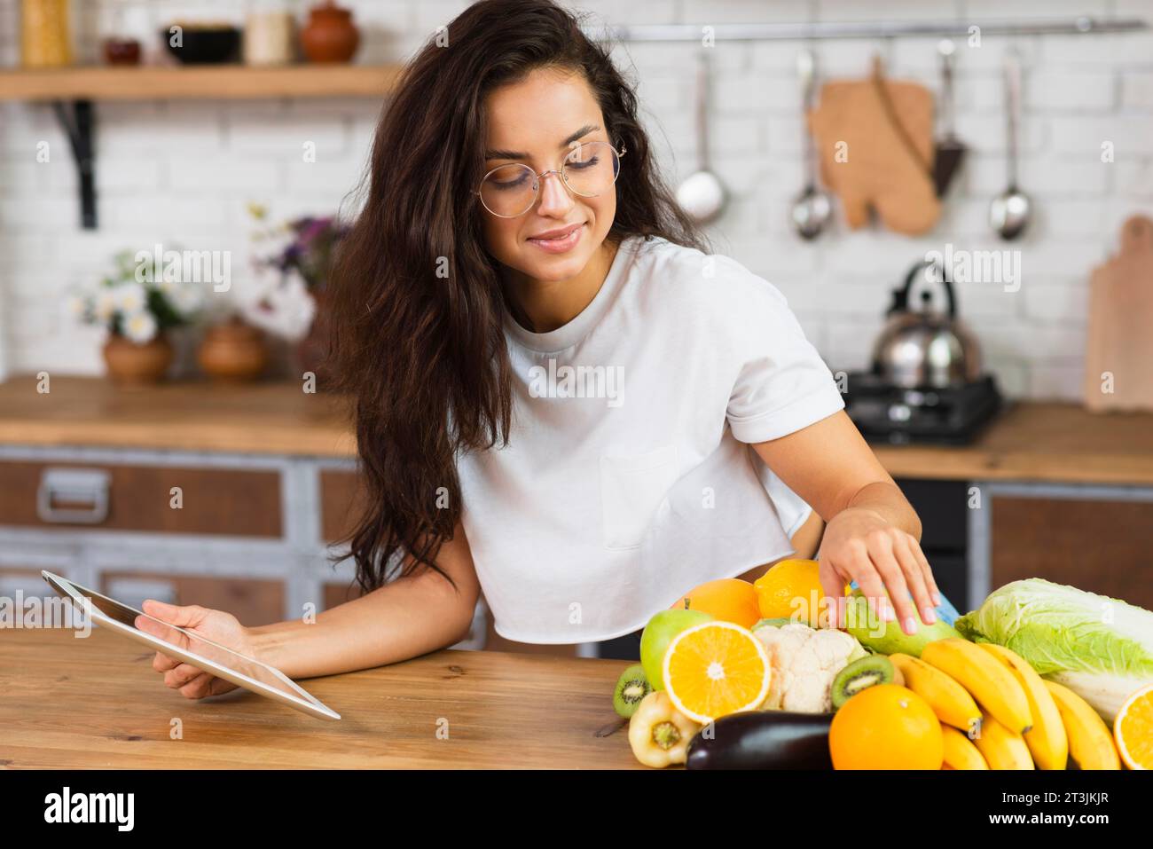 Shot medio per donna con tavoletta di frutta Foto Stock