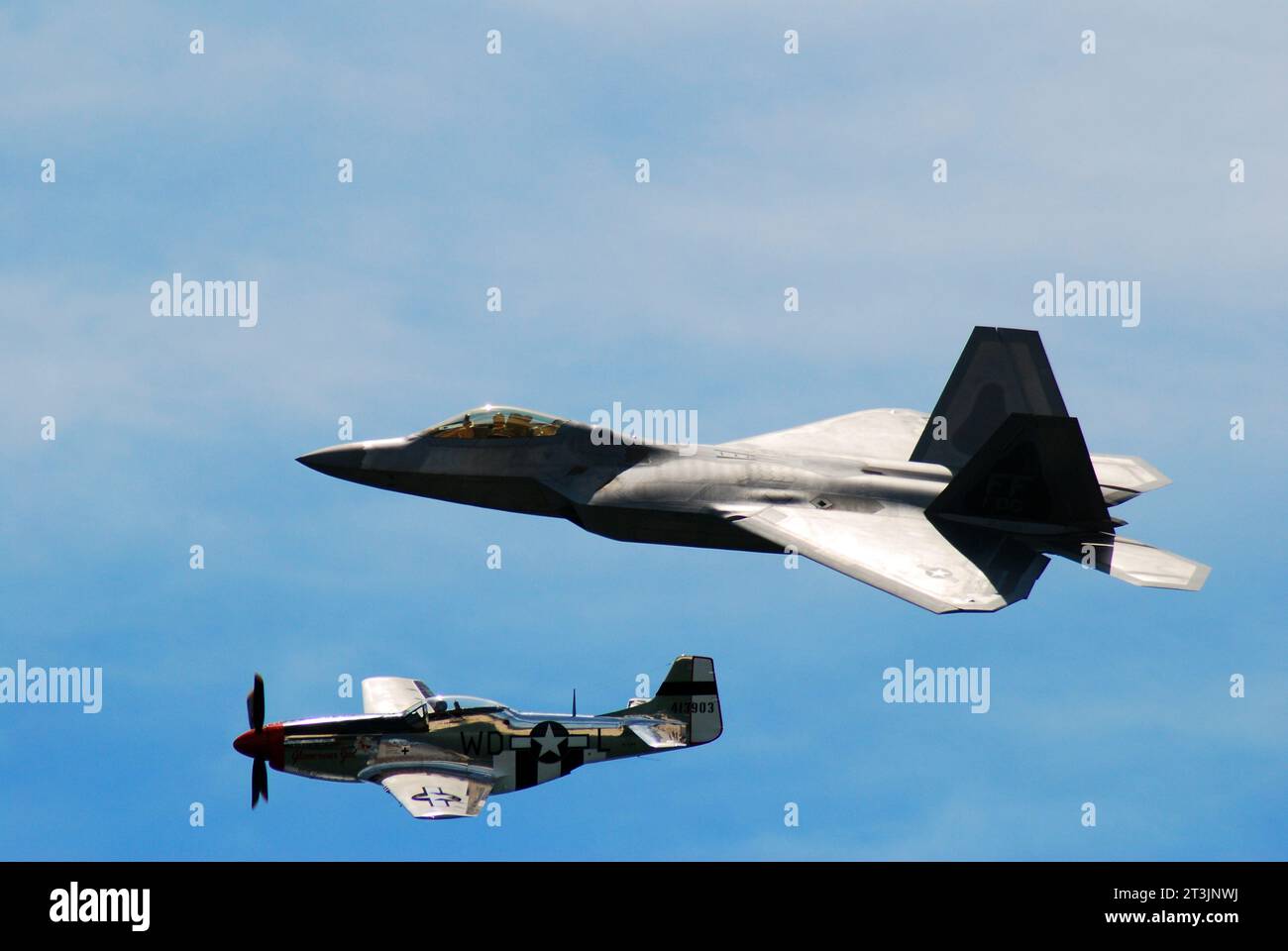 Rappresentando due epoche in volo, un P51 Mustang della seconda guerra mondiale vola fianco a fianco con un moderno aereo militare F 22 Raptor Foto Stock