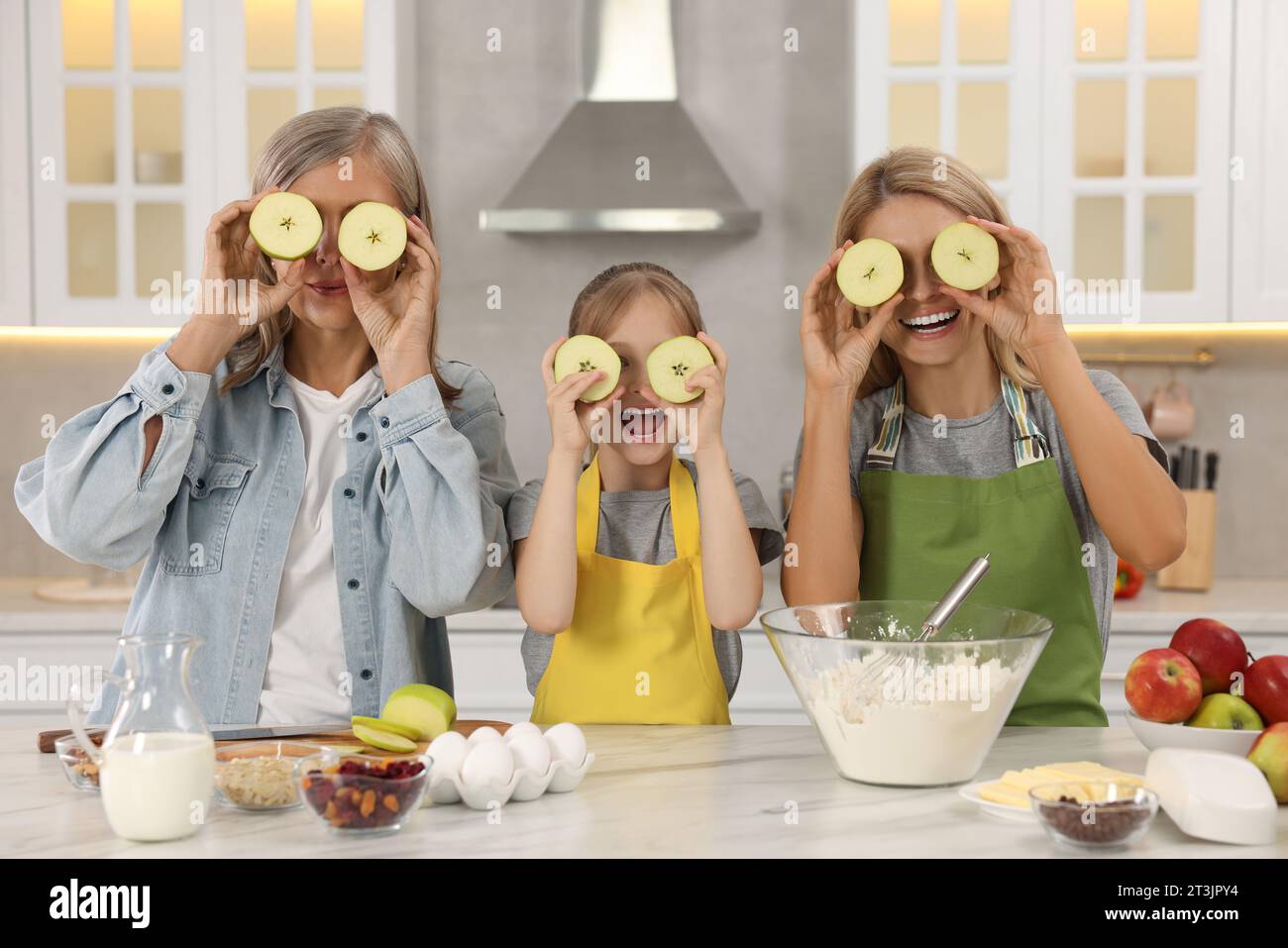 Tre generazioni. La nonna felice, sua figlia e sua nipote si divertono insieme in cucina Foto Stock