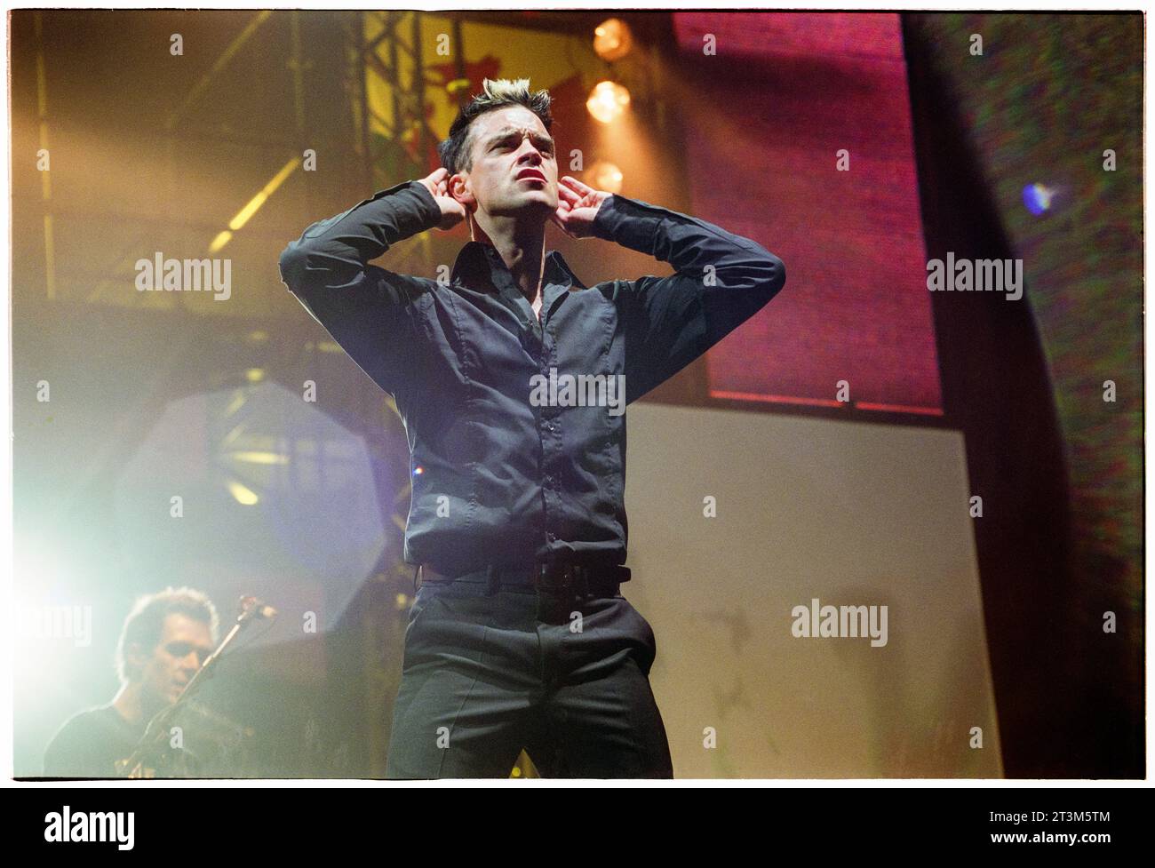 ROBBIE WILLIAMS, CARDIFF, 2001: Robbie Williams ascolta la folla cantare nel suo Weddings, Barmitzvahs & Stadiums tour al Cardiff Arms Park - Millennium Stadium di Cardiff, Galles, Regno Unito il 14 luglio 2001. Foto: Rob Watkins Foto Stock