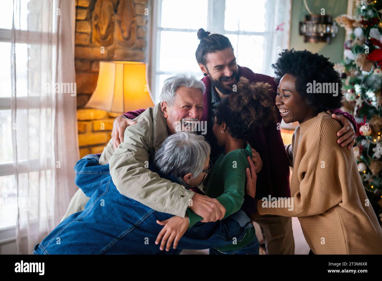 Allegra famiglia multietnica che si diverte festeggiando il Natale insieme a casa. Foto Stock