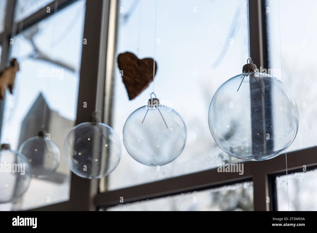 Decorazioni natalizie, palle di vetro trasparente appese di fronte a una finestra Foto Stock