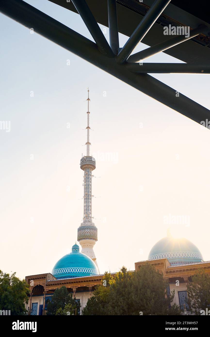 La torre televisiva Tashkent Toshkent Teleminorasi sotto il ponte nel parco al tramonto in Uzbekistan Foto Stock