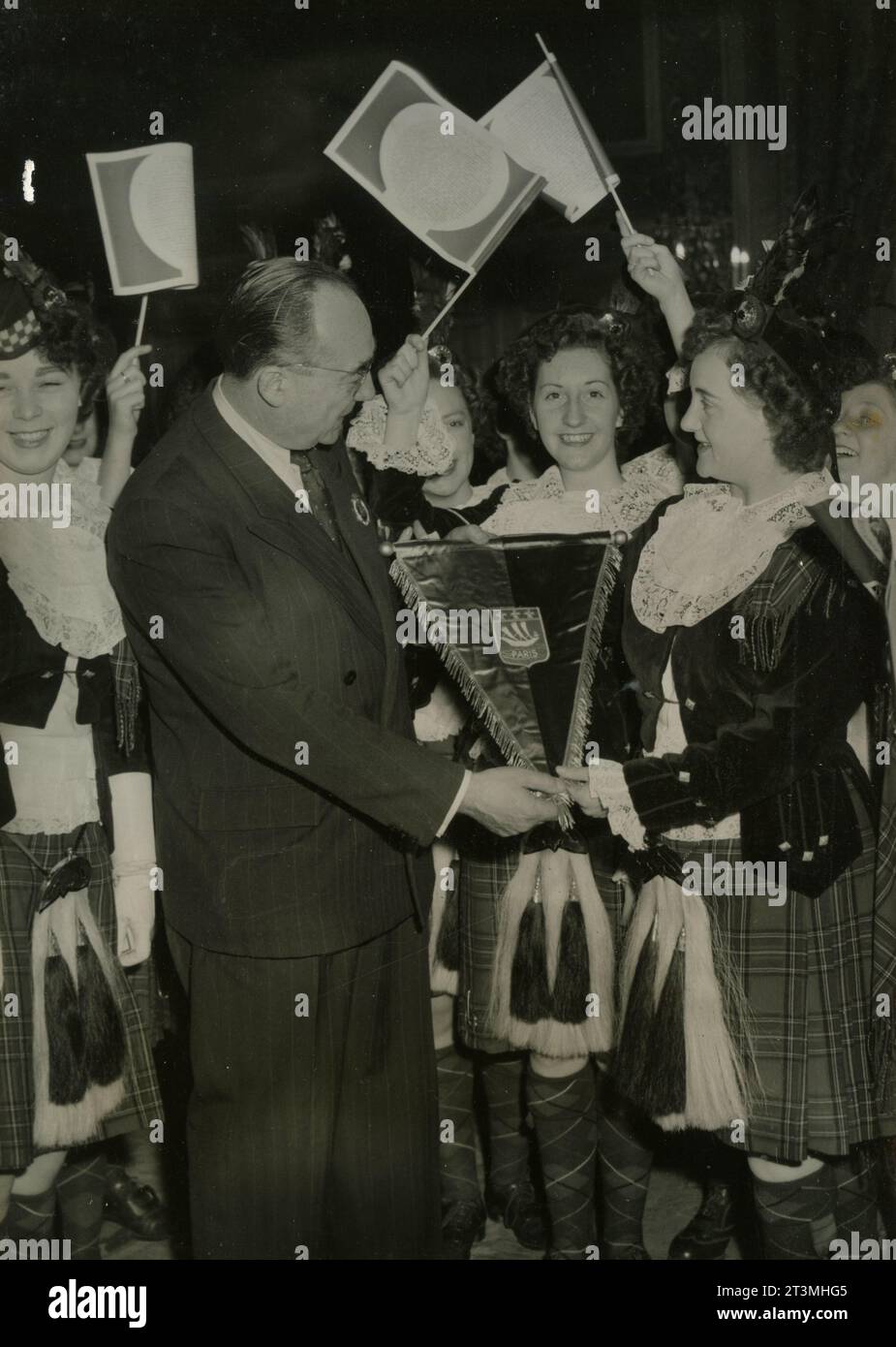 Il politico francese Louis Gidez, vicepresidente del consiglio municipale di Parigi, dà alla Scottish Girl Pipers uno stemma, Francia 1955 Foto Stock