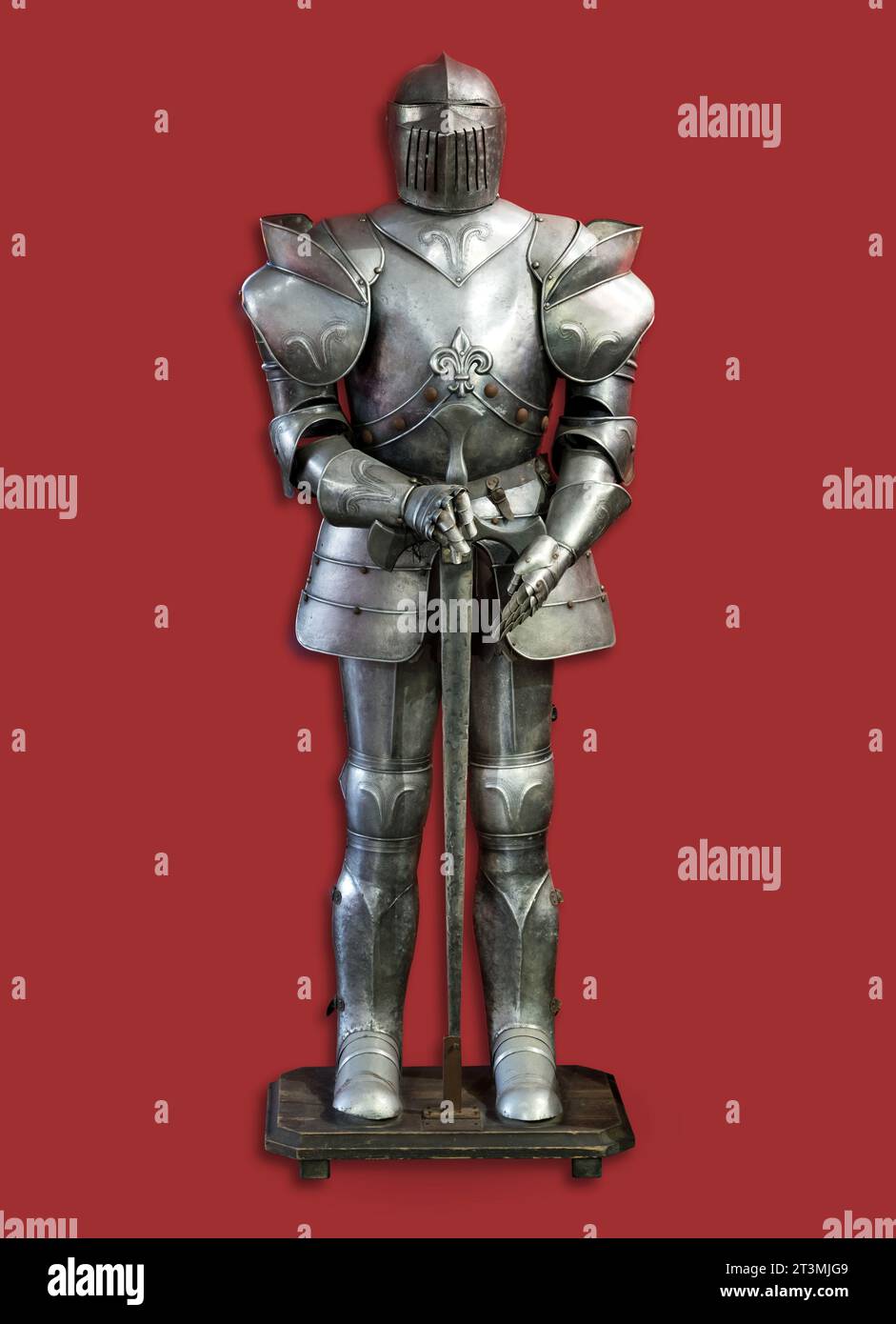 Set di armature di cavaliere in metallo invecchiato posizionato su rack isolato su sfondo rosso Foto Stock