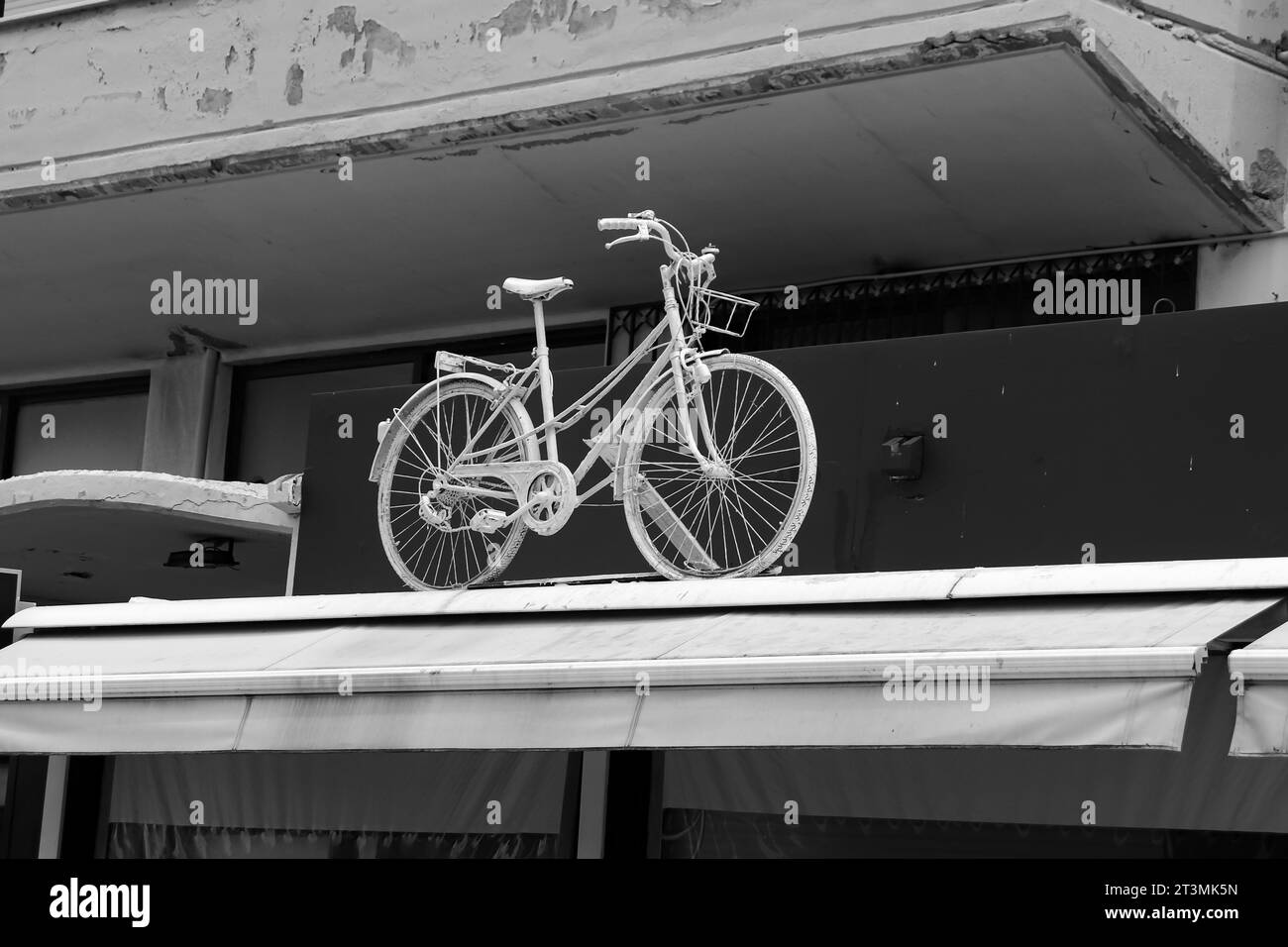 Bicicletta decorativa bianca sulla parte superiore di una tenda da parasole sul tetto anteriore in bianco e nero Foto Stock