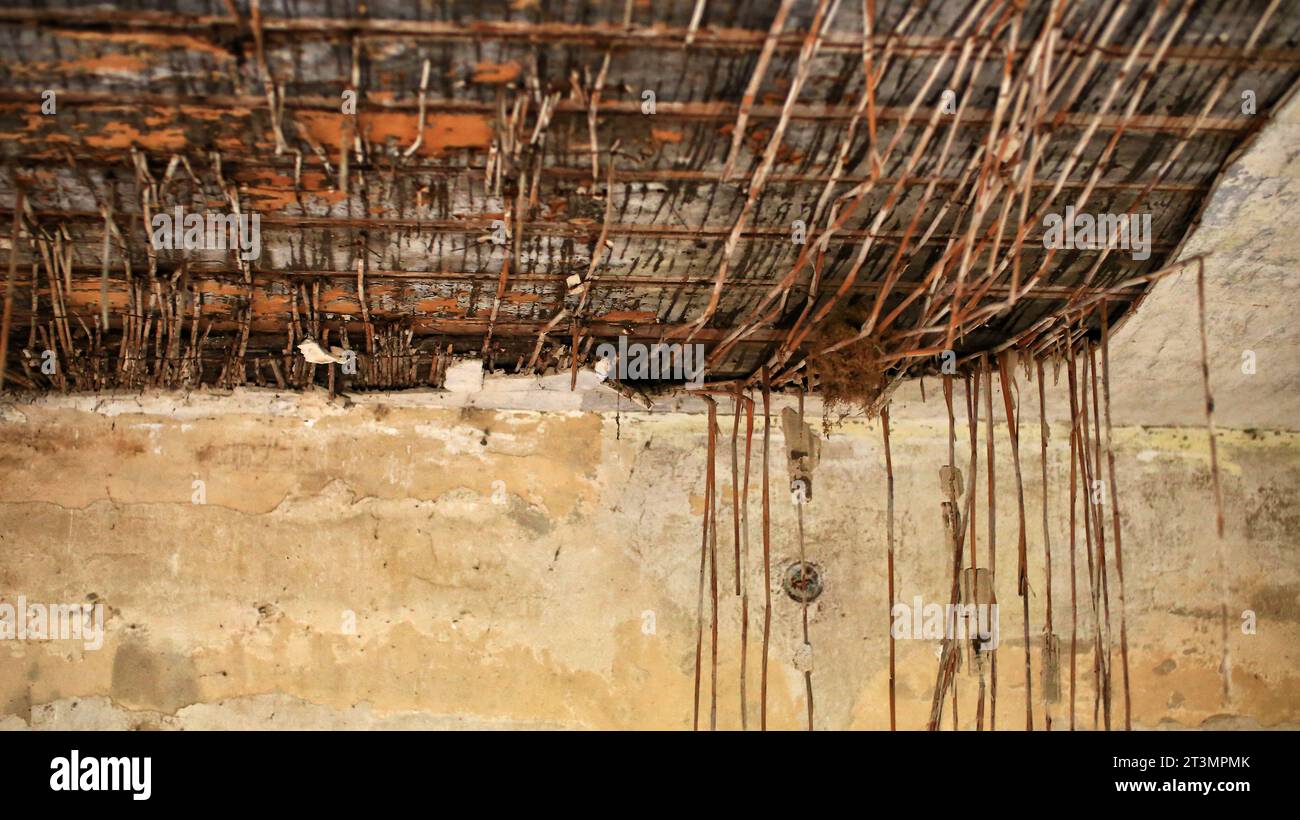 Soffitto rotto con rinforzo a canne e gesso che cade. Foto Stock