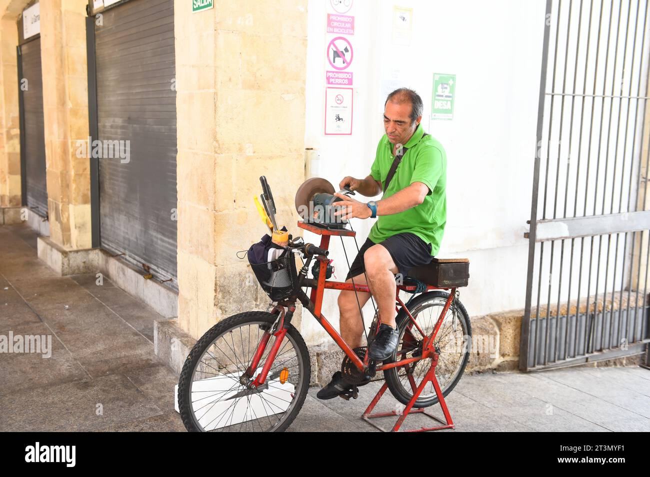 La pietra abrasiva per biciclette viene utilizzata per affilare i coltelli dal commerciante locale di Cadice, Spagna, il 3 agosto 2023 Foto Stock