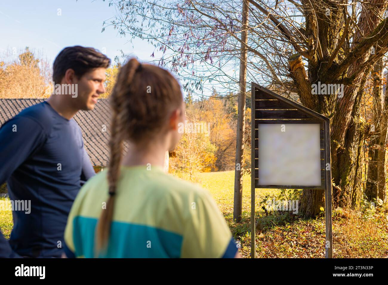 Escursionista, donna e uomo che guardano un tabellone informativo in natura Foto Stock