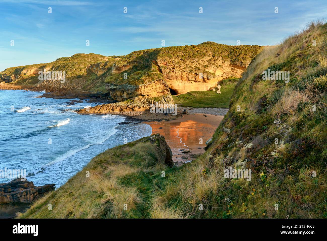 Hopeman Moray Coast Scozia sole e riflesso di una scogliera di arenaria dorata sulla spiaggia sabbiosa Foto Stock