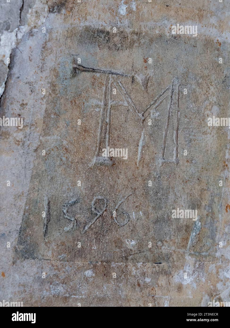 Graffiti "TM 1596" incisi su un mattone nel castello di Upnor, un forte di artiglieria elisabettiana, River Medway, Kent, Regno Unito. Foto Stock