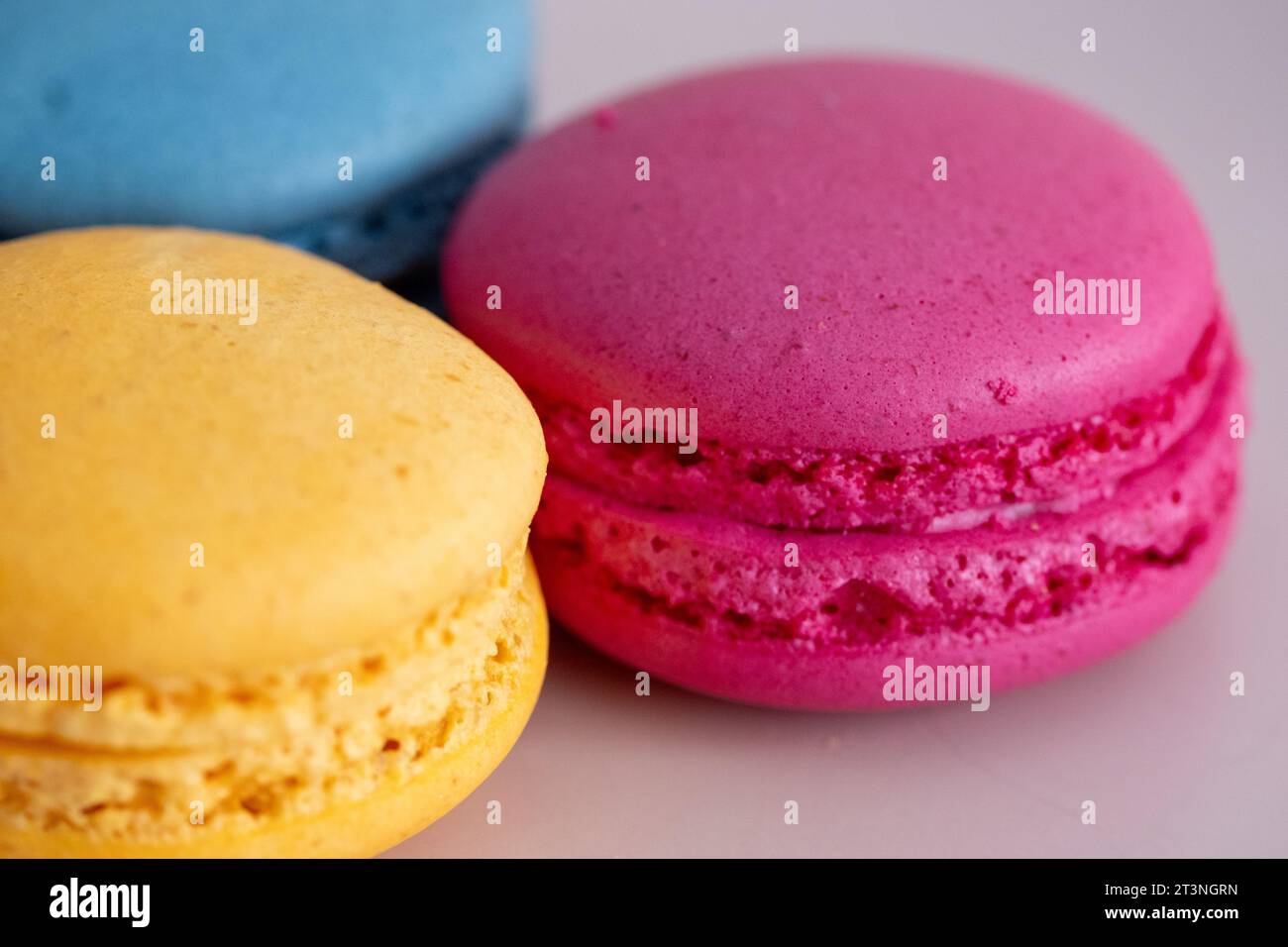 macaron di colori diversi e vari cioccolatini su sfondo bianco in primo piano Foto Stock