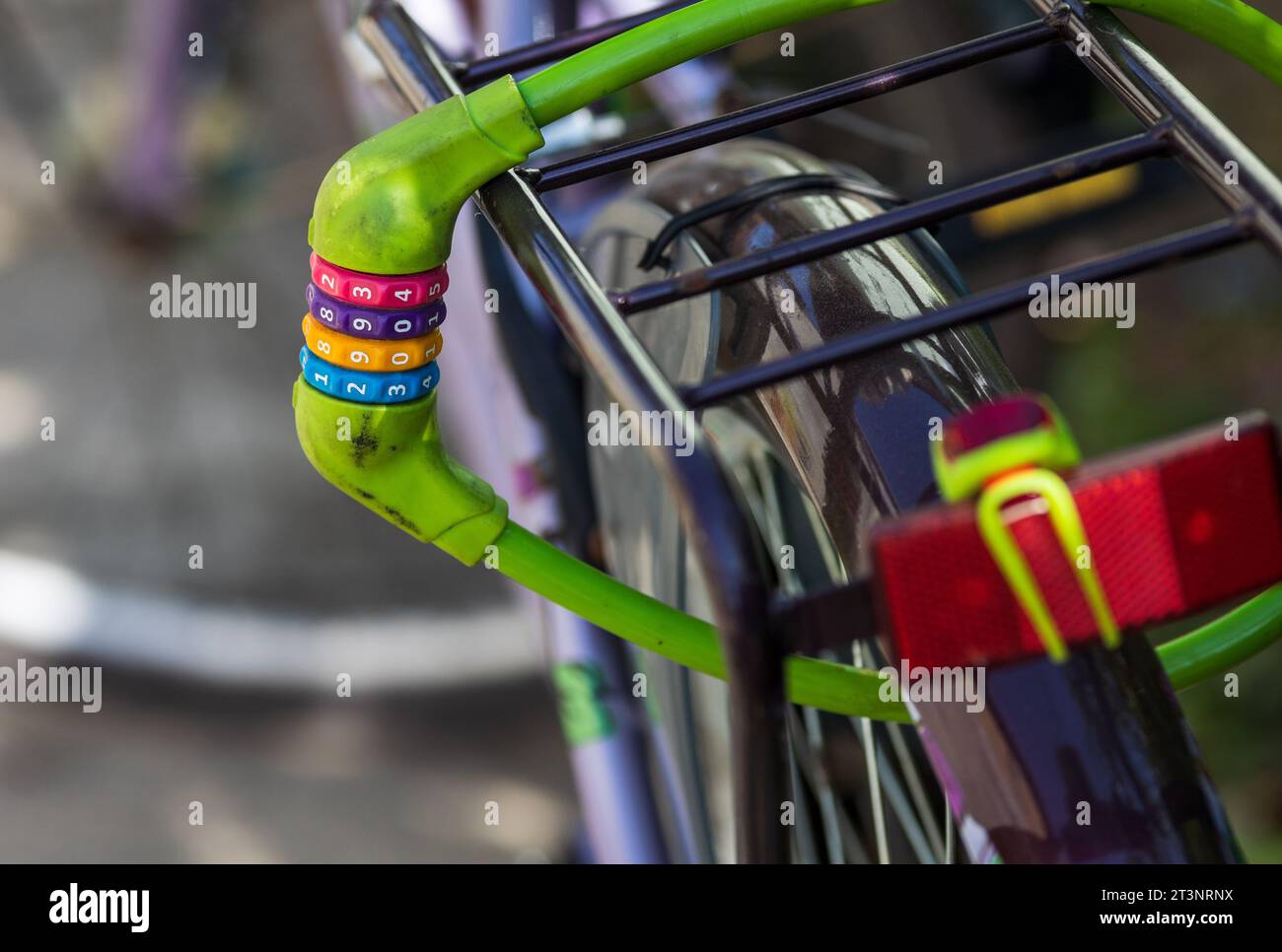 Primo piano del lucchetto colorato per bici sulla ruota e sul portapacchi Foto Stock