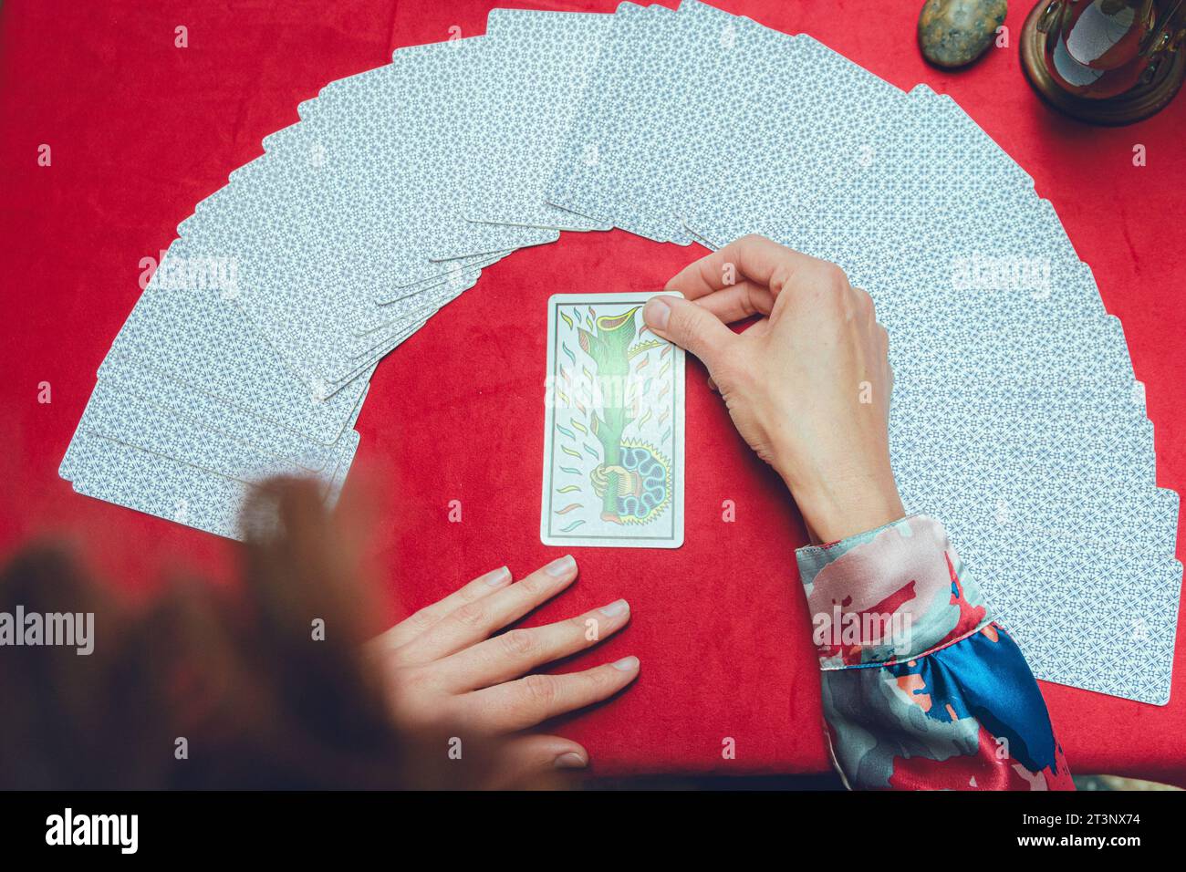 vista dall'alto irriconoscibile lettore di tarocchi di donna caucasica che tiene la carta con le mani sul tavolo, interpreta e fa lettura, collegandosi con le energie di Foto Stock vista dall'alto irriconoscibile lettore di tarocchi di donna caucasica che tiene la carta con le mani sul tavolo, interpreta e fa lettura, collegandosi con le energie di Foto Stock