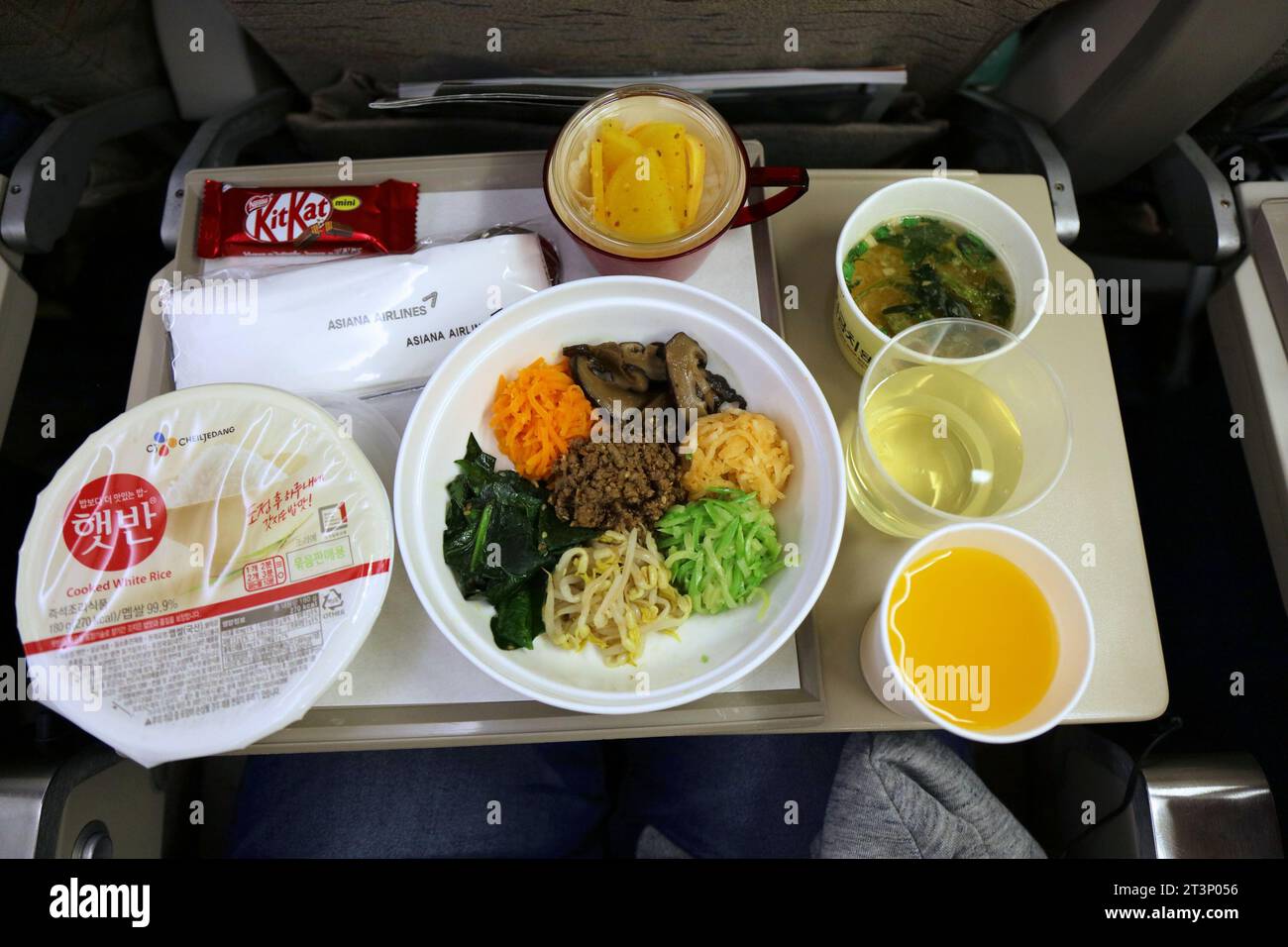 SEUL, COREA DEL SUD - 25 MARZO 2023: Tavolo dei pasti della compagnia aerea a bordo di Asiana Airlines. Cena di cucina coreana con bibimbap. Foto Stock