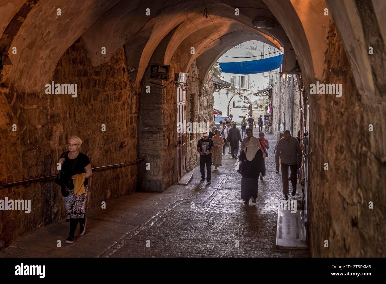 I turisti che attraversano un arco buio nella città vecchia di Gerusalemme, in Israele. Foto Stock