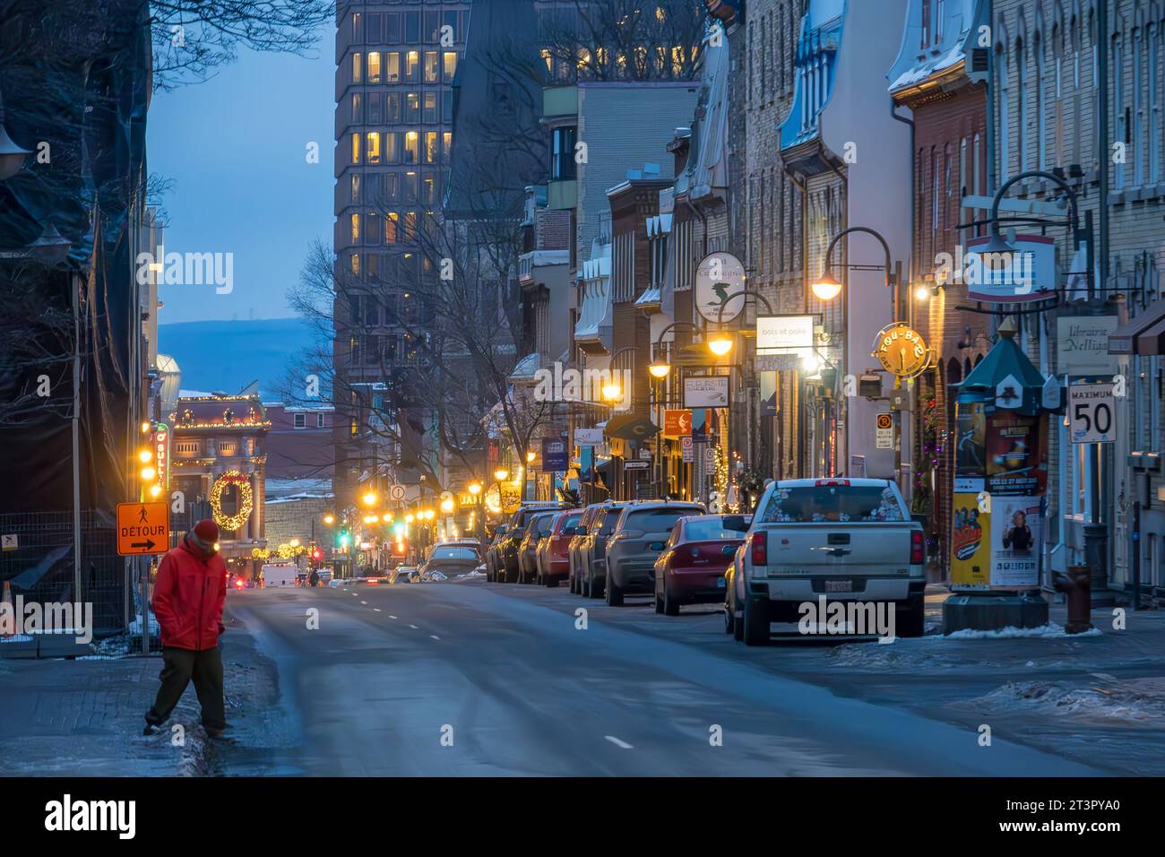Una passeggiata pedonale che attraversa la strada in una sera d'inverno, nella Vecchia Quebec City, nella Provincia di Quebec, Canada. Possiamo vedere Chateau Frontenac in cima Foto Stock