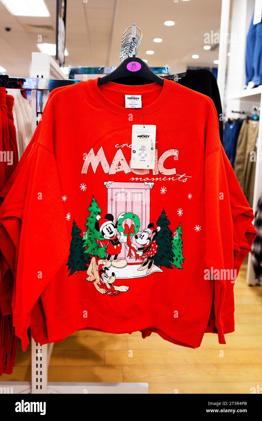 Collezione di maglie natalizie Primark 2023 - Mini e mouse con illustrazione della scena natalizia Pluto su maglione rosso e slogan "Create Magic Moment" Foto Stock