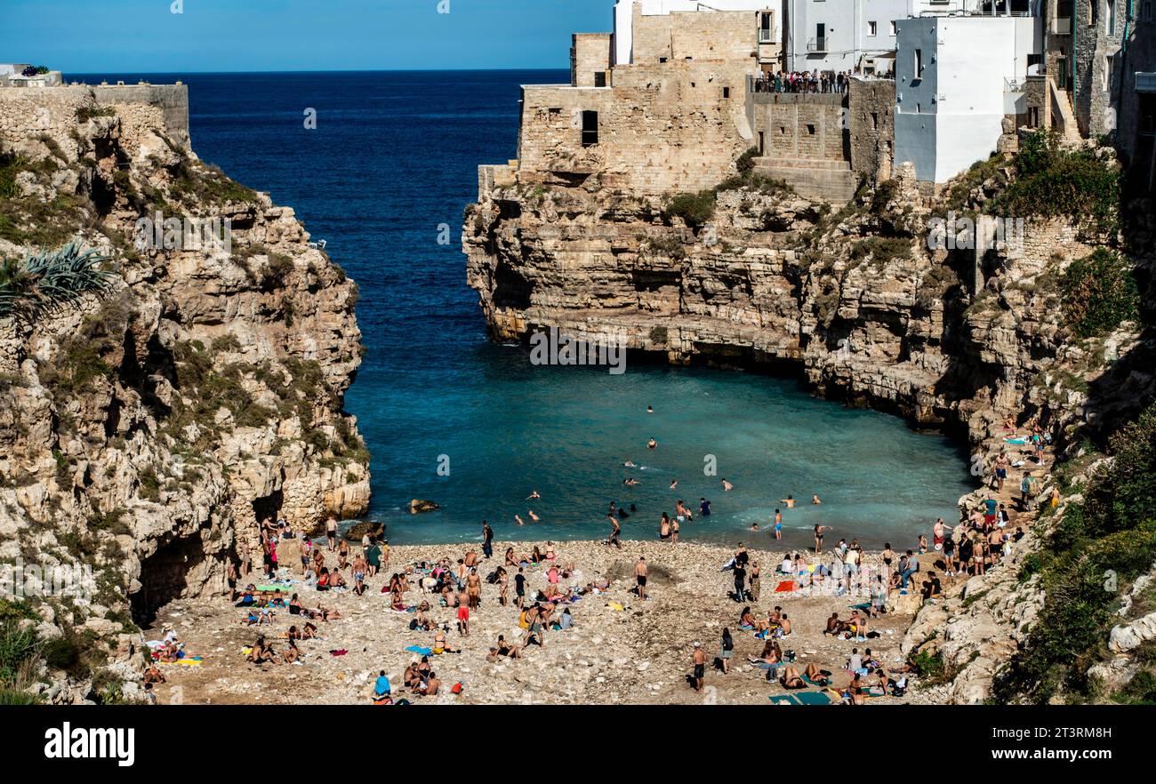 Gente che si gode la spiaggia di Cala Ponte a Polignano a Mare, IIaly, in una domenica soleggiata pomeriggio di ottobre. Foto Stock