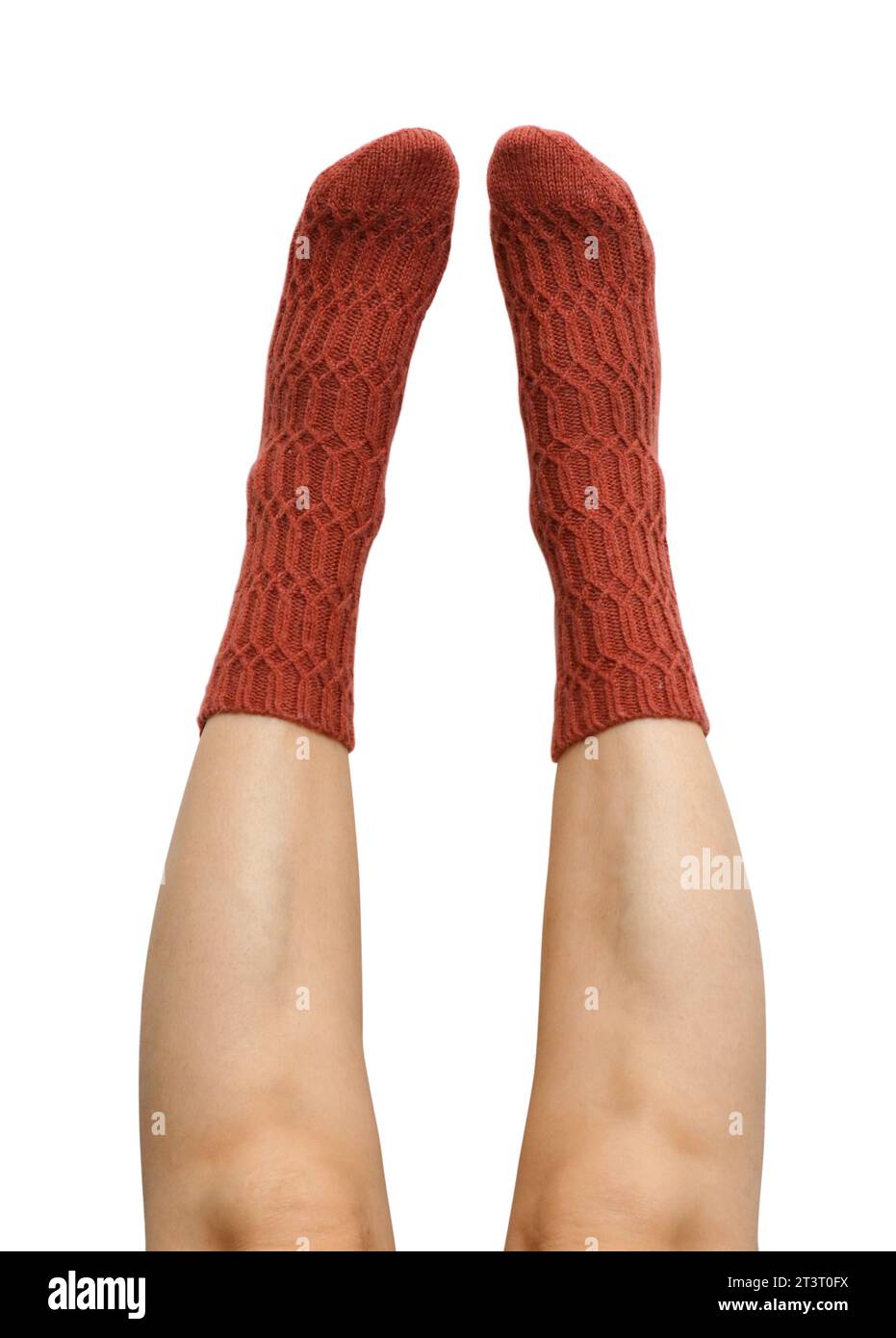 Gambe femminili in calze di lana lavorate a mano in terracotta isolate su sfondo bianco, percorso di ritaglio incluso Foto Stock