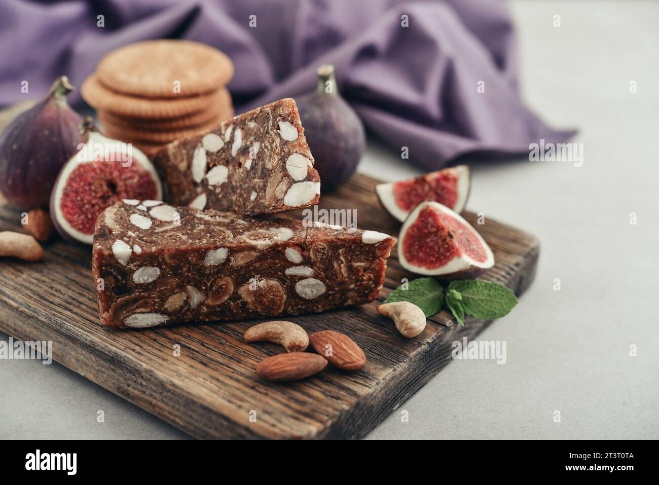 Pan de Higo - pane di fichi spagnolo al tagliere di legno con fichi freschi e primi piani di mandorle Foto Stock