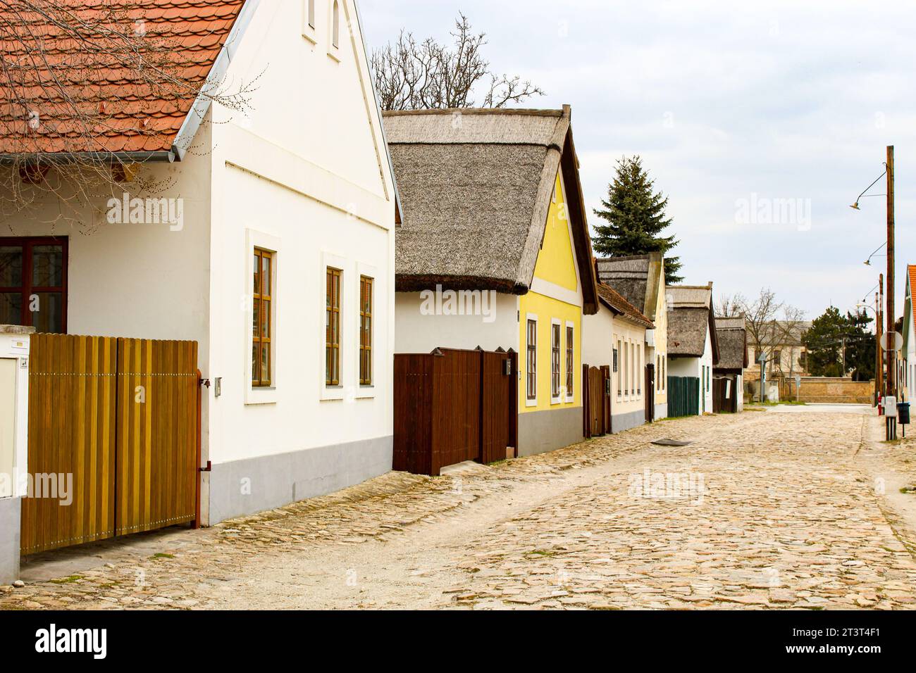 Una strada costituita da vecchie case coloniche con una strada lastricata in pietra in Ungheria Foto Stock