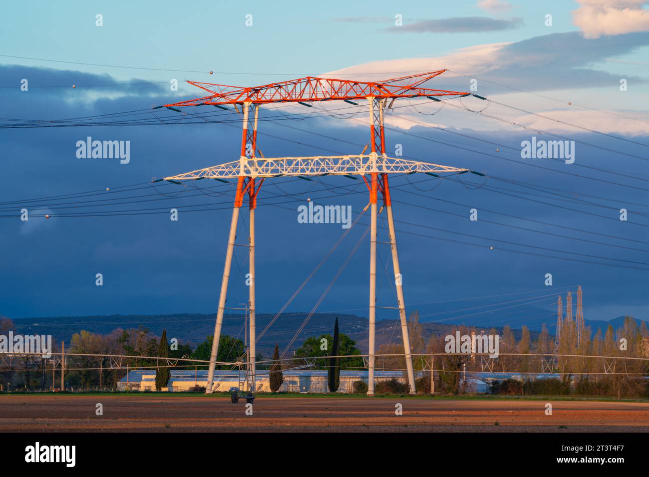 Torri elettriche ad alta tensione durante il tramonto. Foto Stock