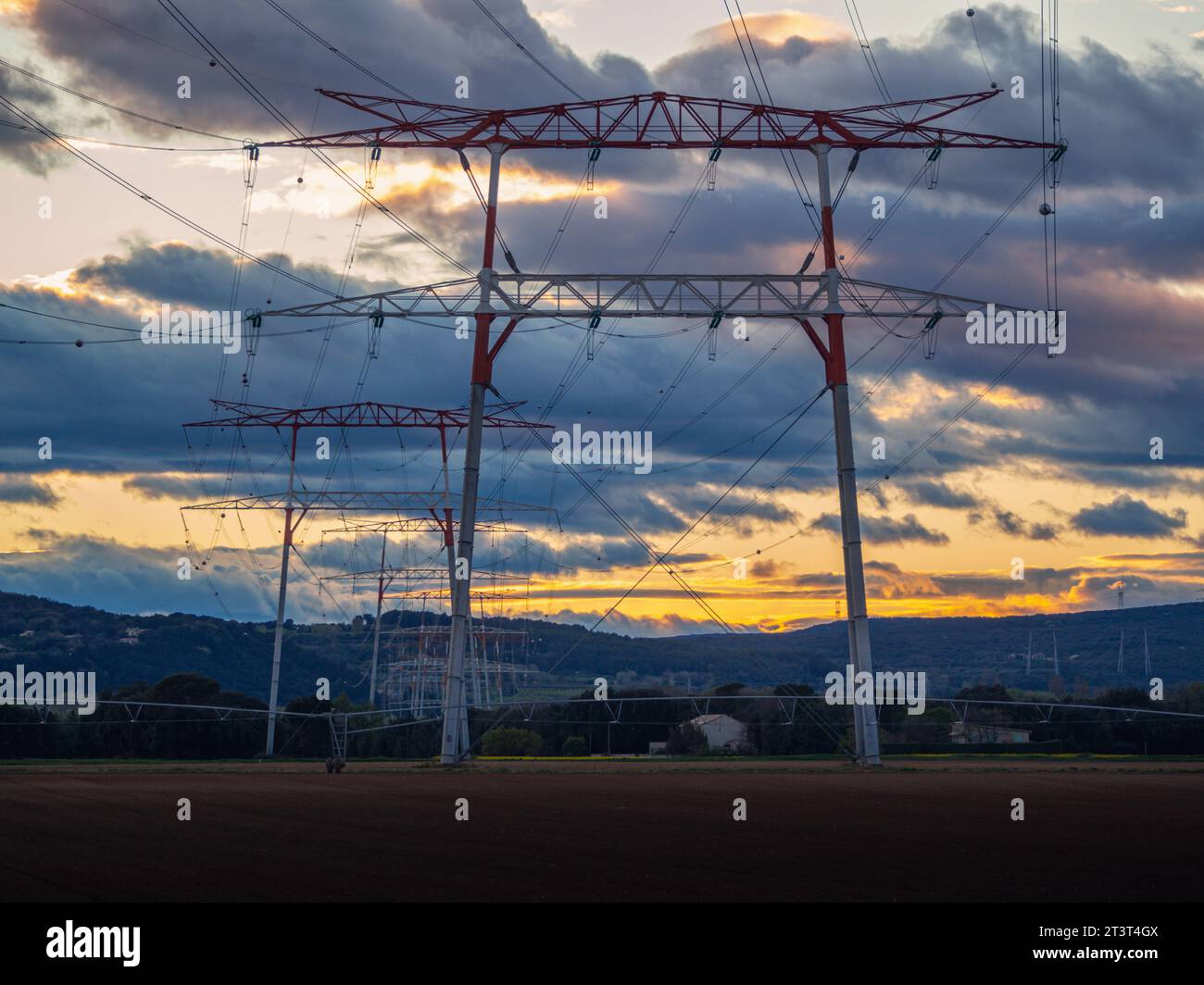 Torri elettriche ad alta tensione durante il tramonto. Foto Stock