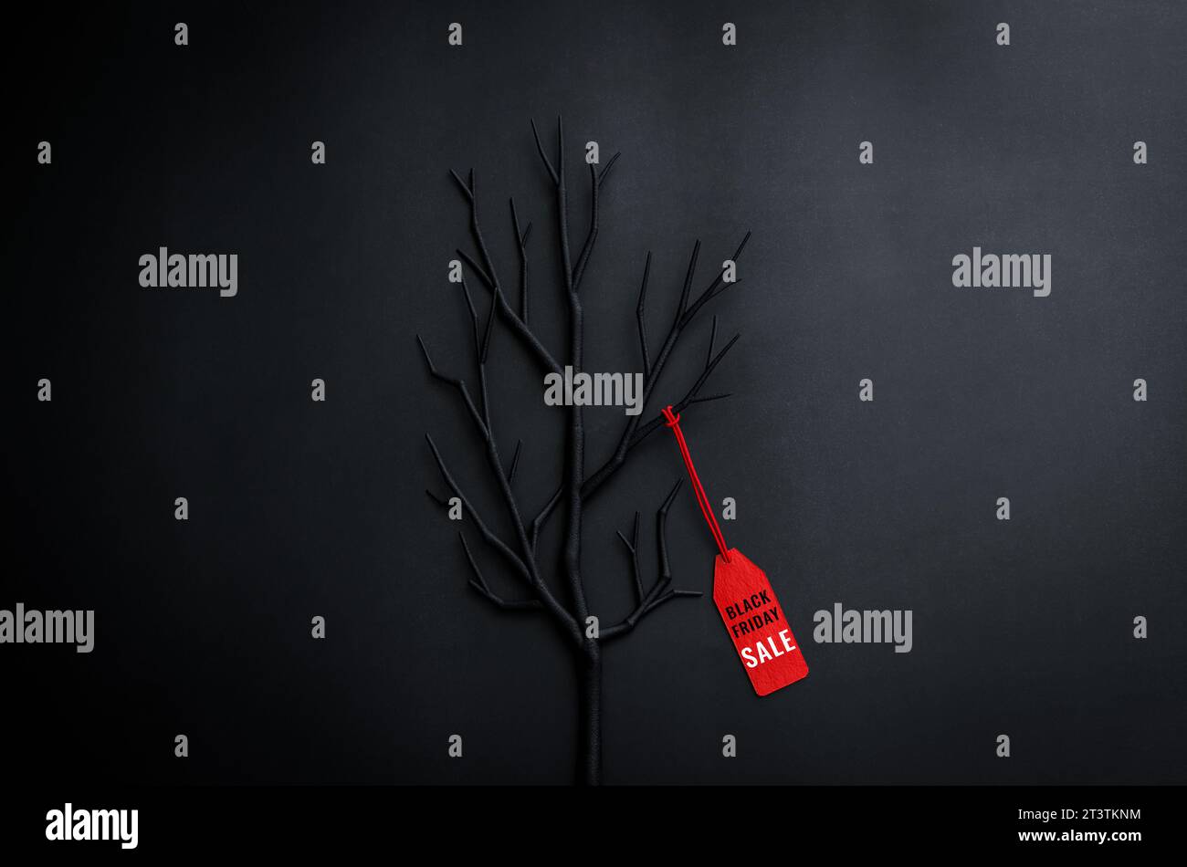 Albero nero con rami con indicazione di prezzo rossa su sfondo scuro per il concetto di vendita per lo shopping del Black Friday. Foto Stock