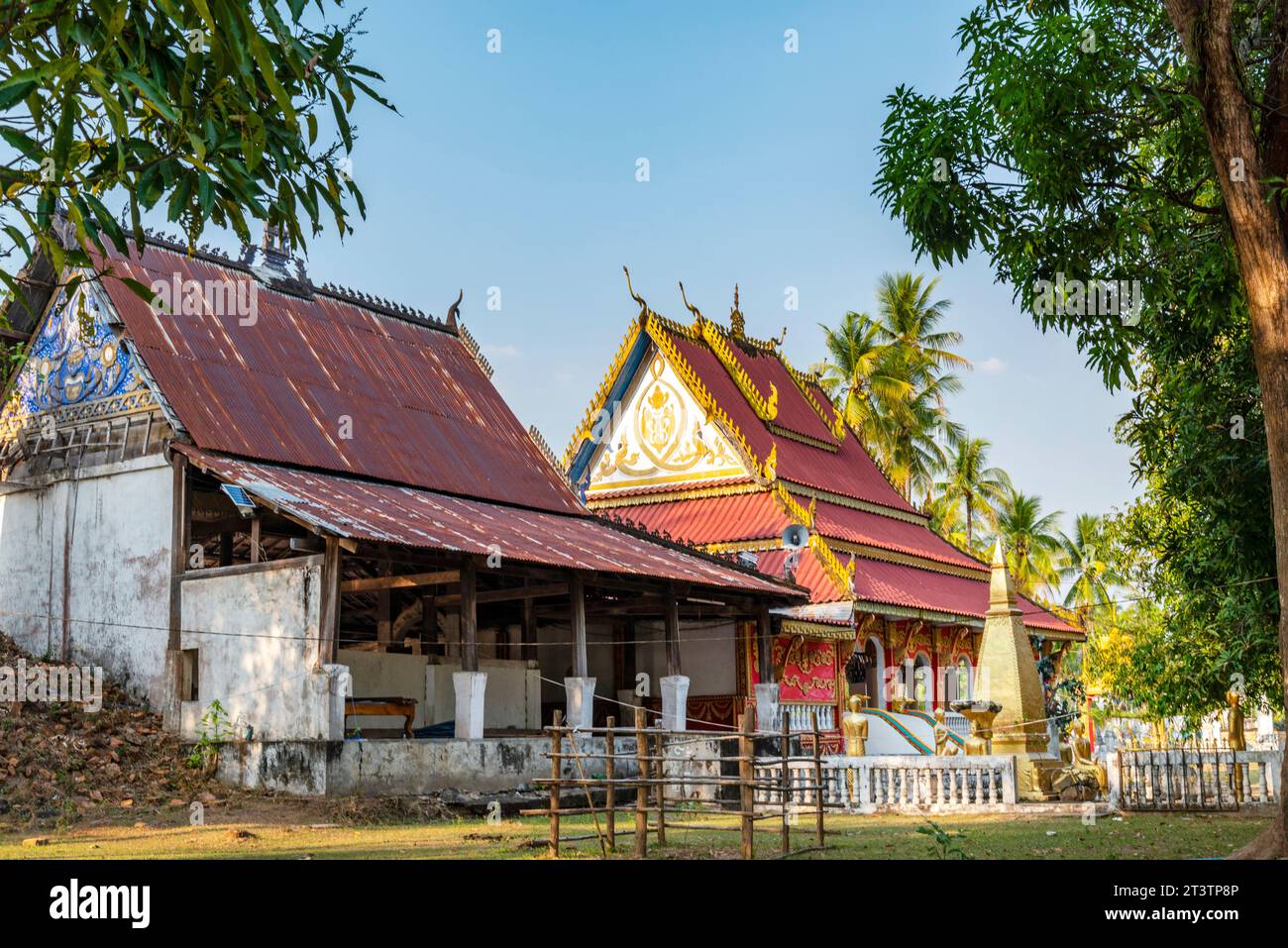 Piccolo tempio buddista sull'isola di Don Khone. Splendidi edifici antichi, nel tardo pomeriggio, circondati da molti alberi frondosi, che donano ombra in un tranquillo su Foto Stock