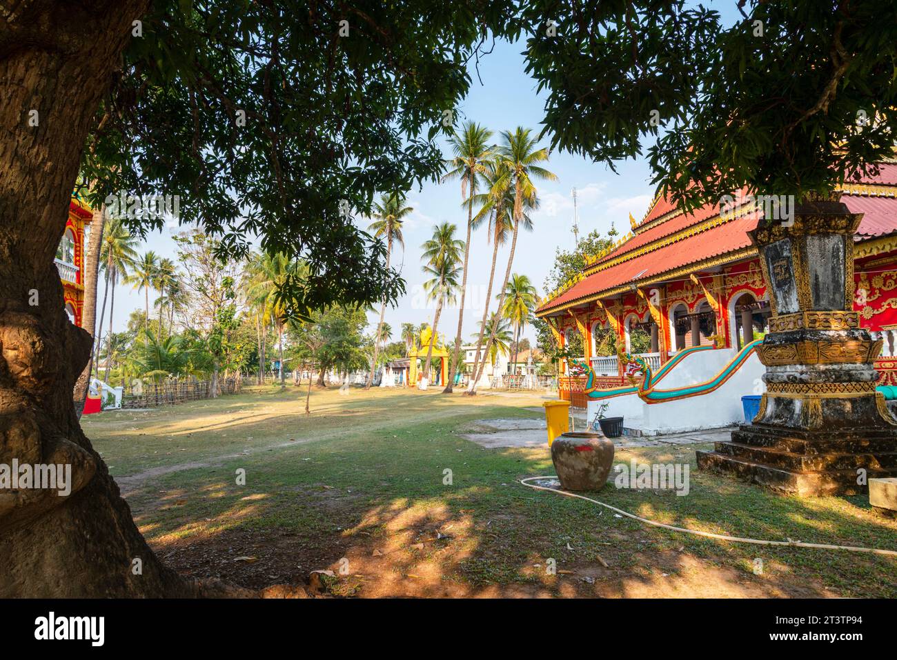 Piccolo tempio buddista sull'isola di Don Khone. Splendidi edifici antichi, nel tardo pomeriggio, circondati da molti alberi frondosi, che donano ombra in un tranquillo su Foto Stock
