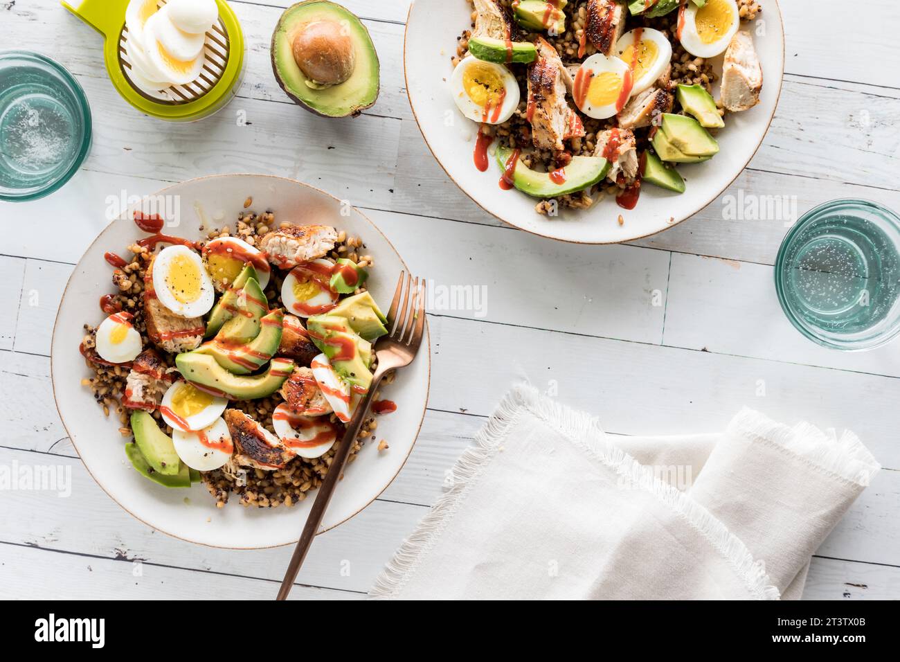 Ciotole di proteine sane fatte in casa, tra cui uova, pollo e avocado. Foto Stock