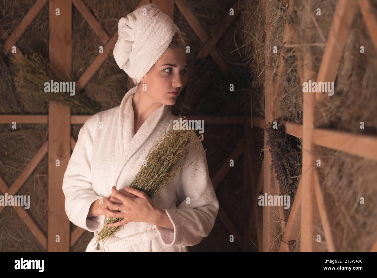 Accappatoio giovane donna in possesso di erbe mediche Foto Stock
