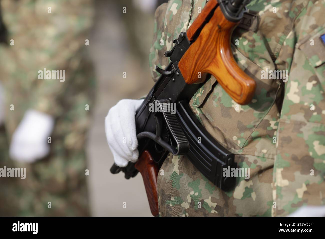 Dettagli poco profondi di campo (fuoco selettivo) con la museruola di un fucile AK47 nelle mani di un soldato rumeno. Foto Stock