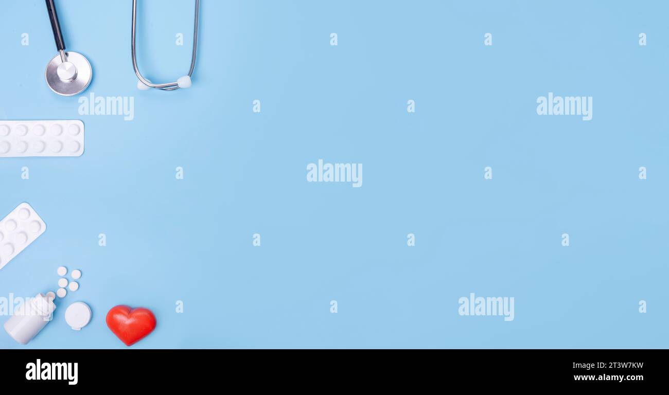 Compresse, medicina, cuore e stetoscopio su sfondo blu. Idea per l'assistenza sanitaria, l'assicurazione sanitaria e i farmaci cardiaci. Comprare e comprare medicine Foto Stock